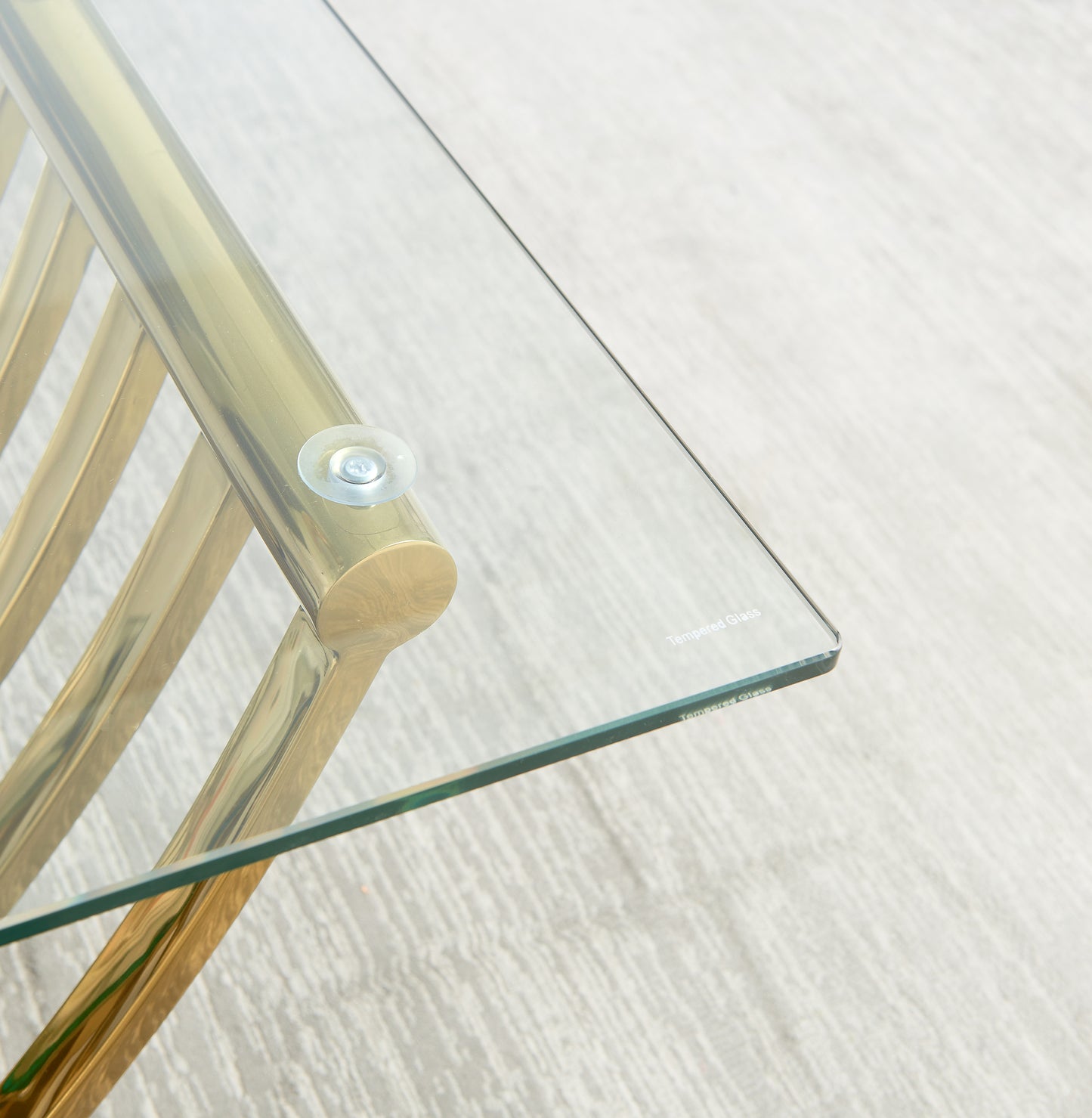 Closeup of modern brass coffee table frame with glass top