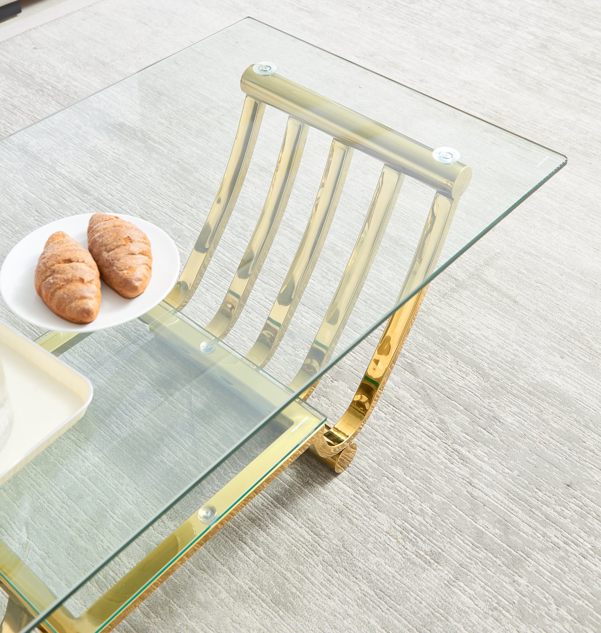 Modern gold accent glass coffee table with intricate brass legs a chic centerpiece