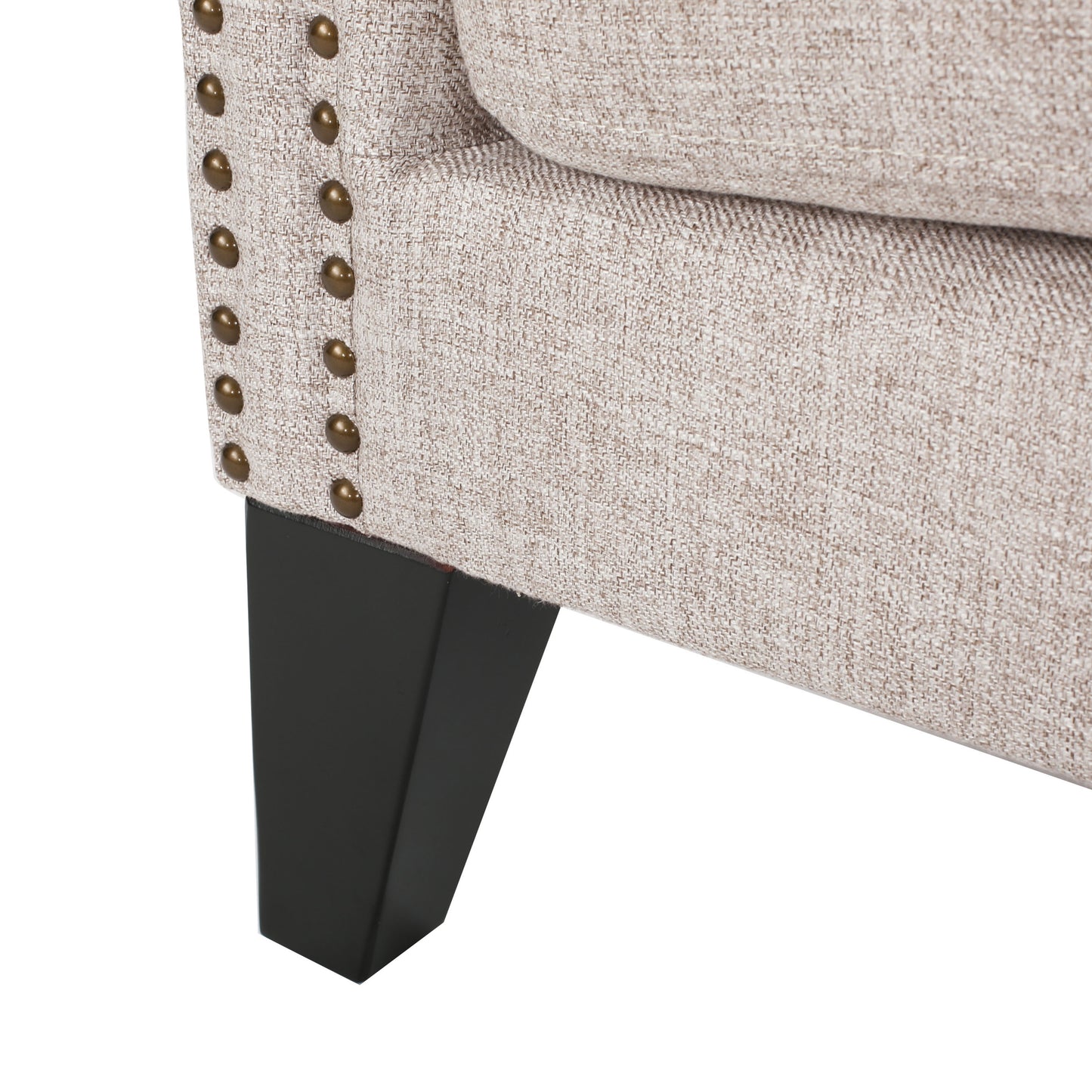 Light beige woven armchair detail with antique brass nailhead trim and dark wood leg