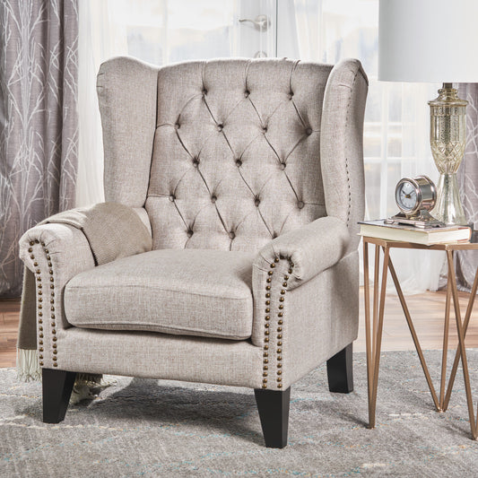 Tufted beige accent chair with brass nailhead trim and rolled arms