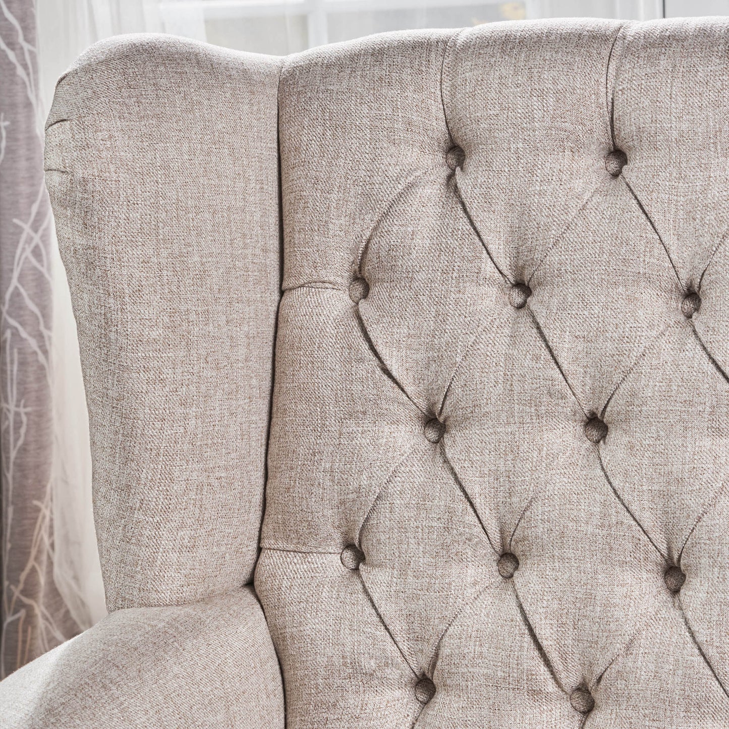 Tufted beige linen upholstered wingback armchair side profile with diamond stitching detail