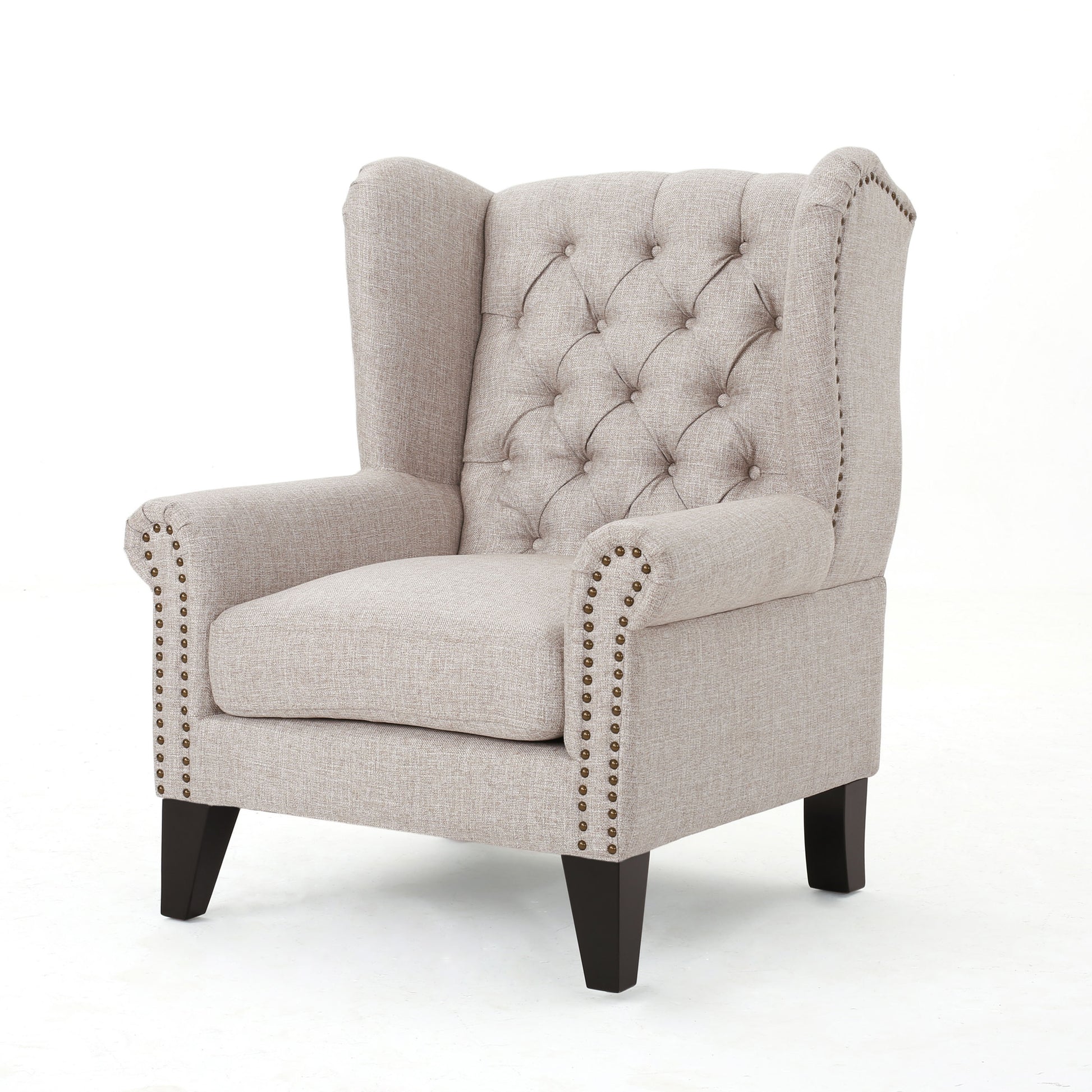 Tufted beige linen wingback chair with nailhead trim perfect for a reading nook