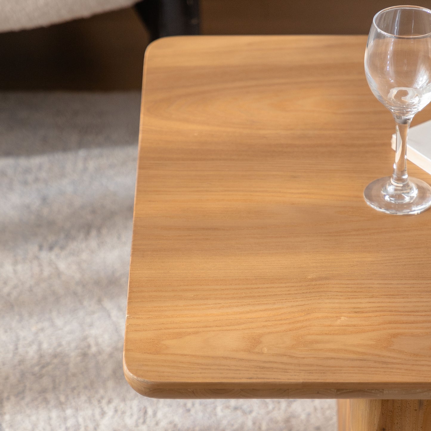 Round glass on light oak coffee table surface with subtle wood grain