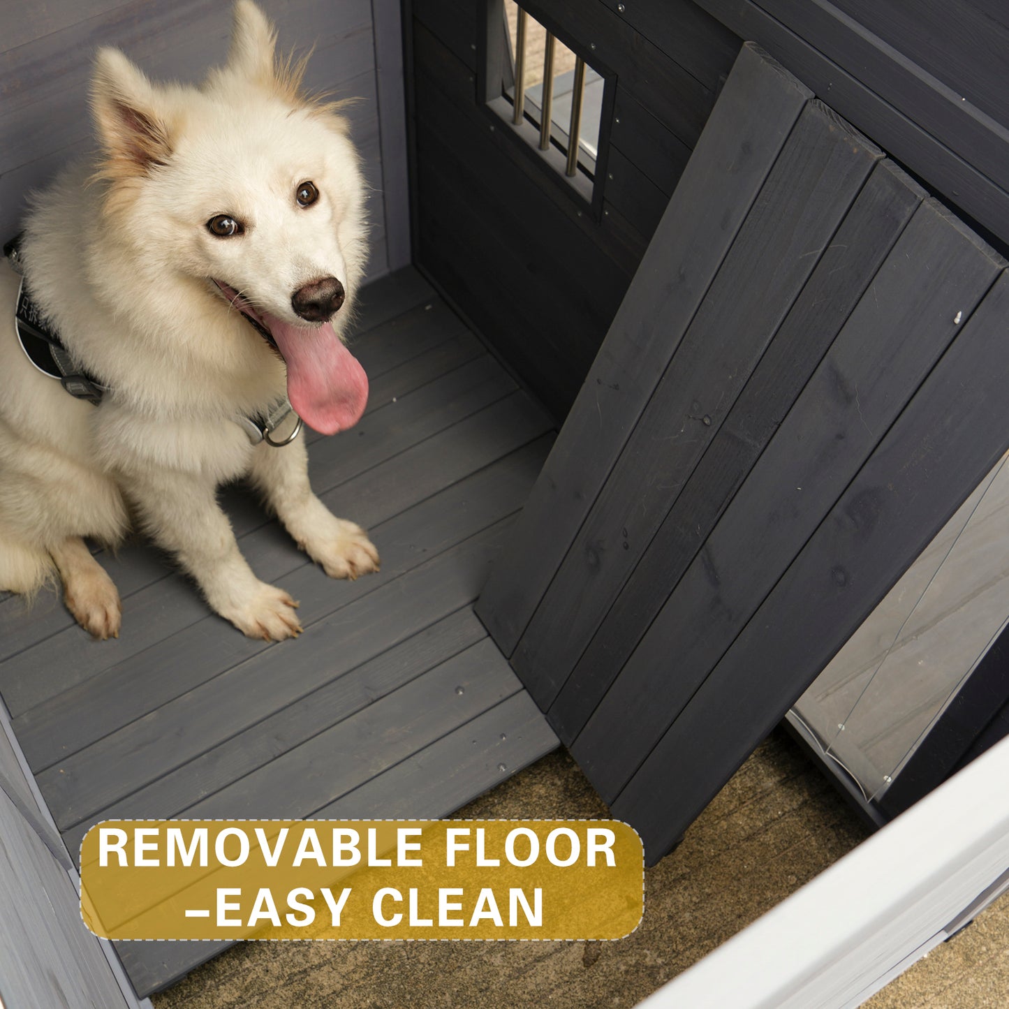 White fluffy dog with tongue out sitting in a dark gray wooden dog house with removable floor