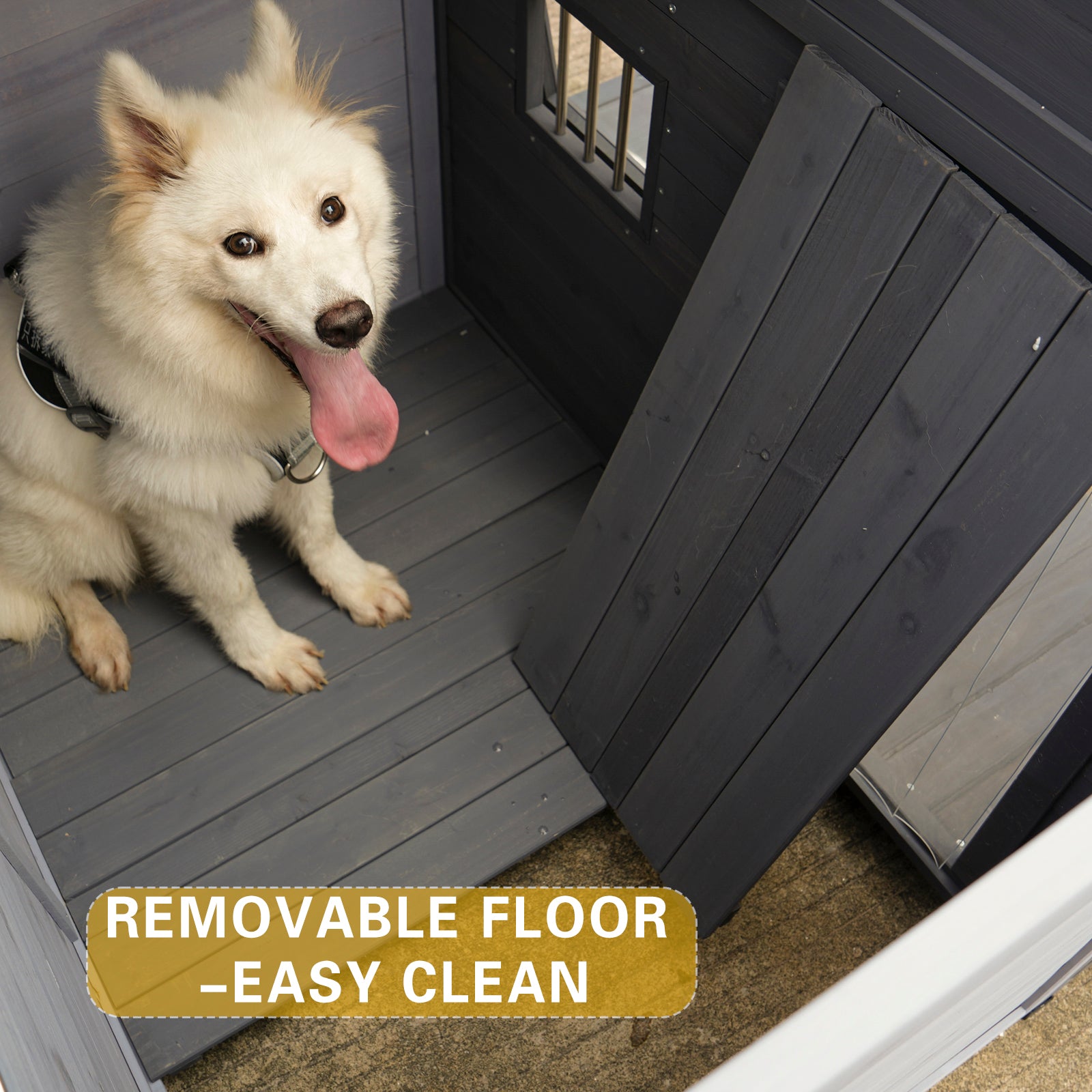 White fluffy dog with tongue out sitting in a dark gray wooden dog house with removable floor