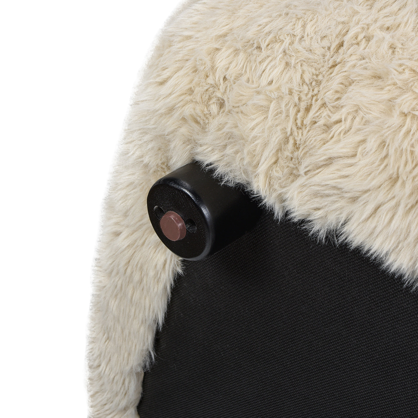 Closeup of a black furniture leg with a beige shaggy rug texture