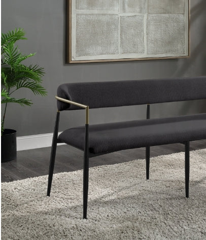 Dark gray upholstered bench with gold armrest accents and black tapered legs