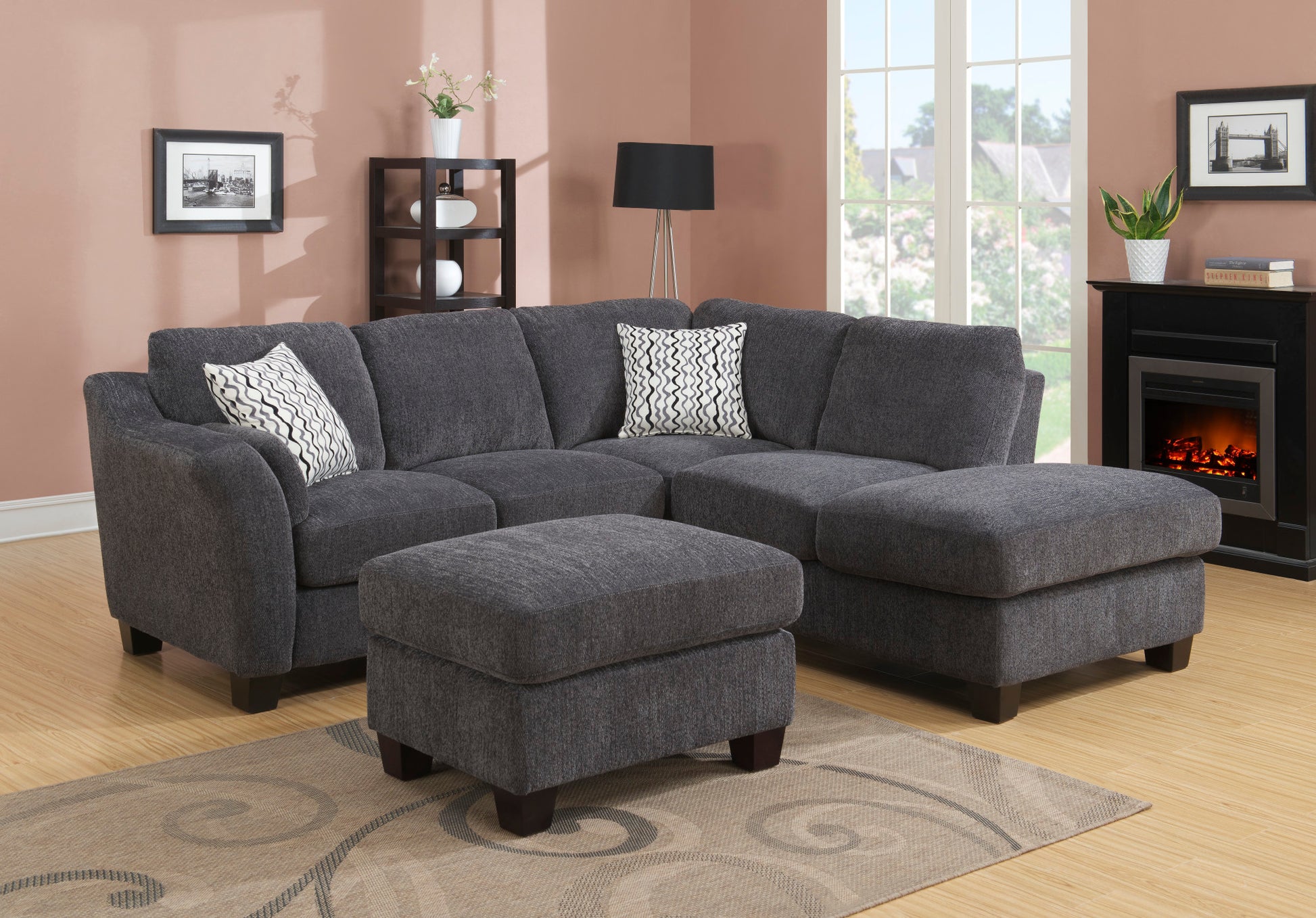 Dark grey fabric sectional sofa with geometric pattern throw pillows and matching ottoman