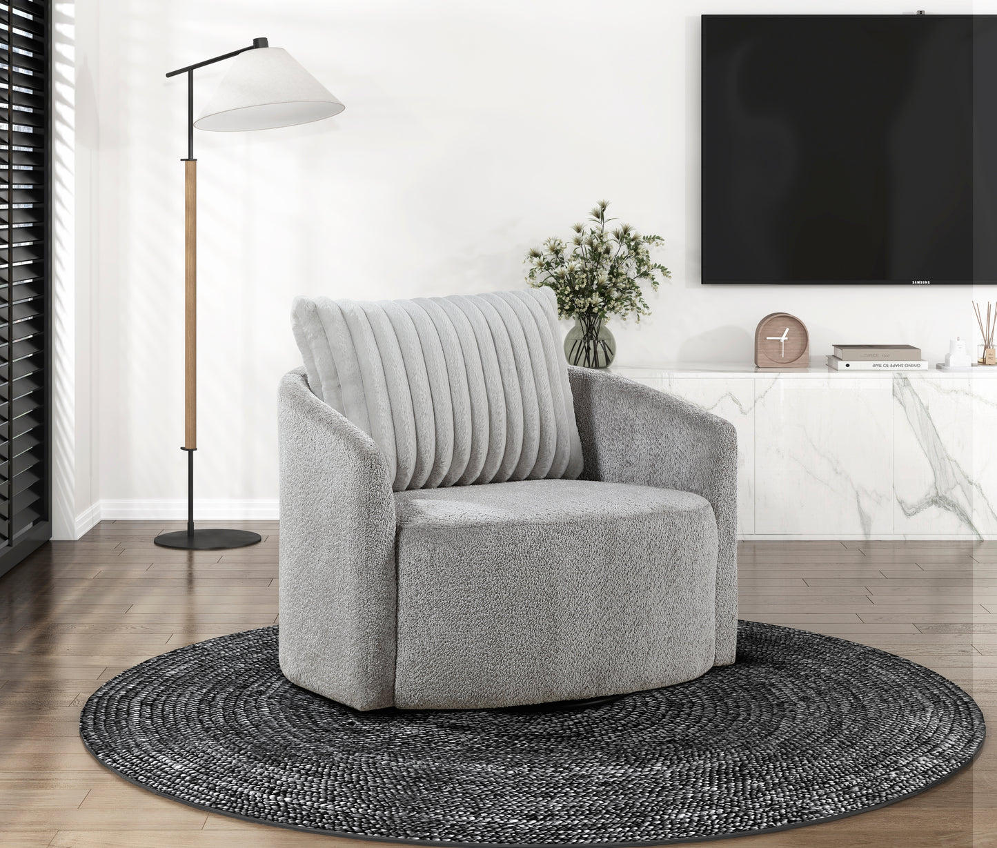 Plush grey swivel armchair with a textured finish and plush ribbed back cushion