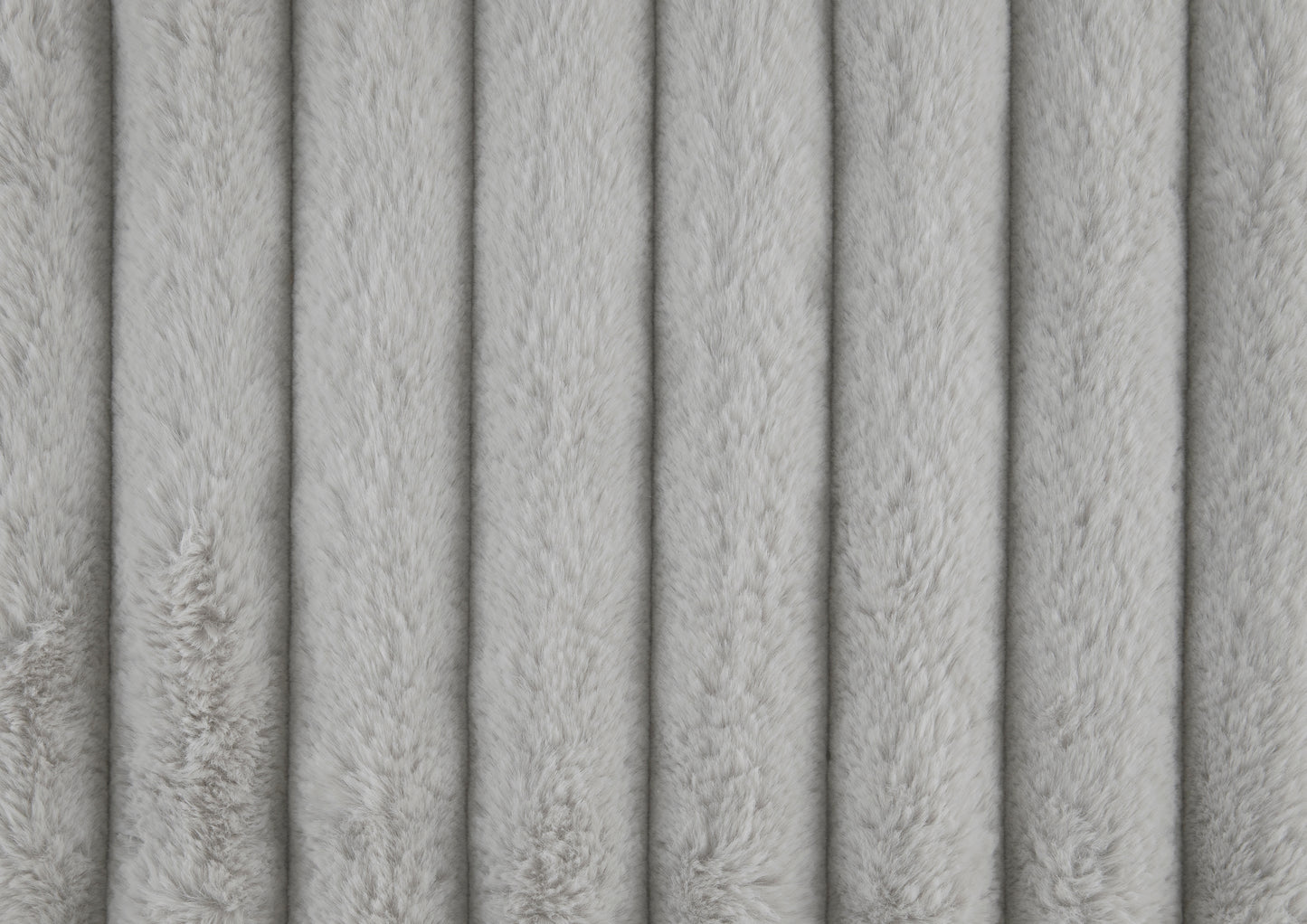 Closeup of soft light gray faux fur fabric with vertical channel quilting