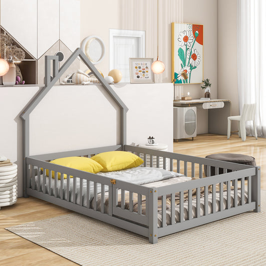 Gray wooden toddler bed with a houseshaped frame safety rails and two yellow pillows