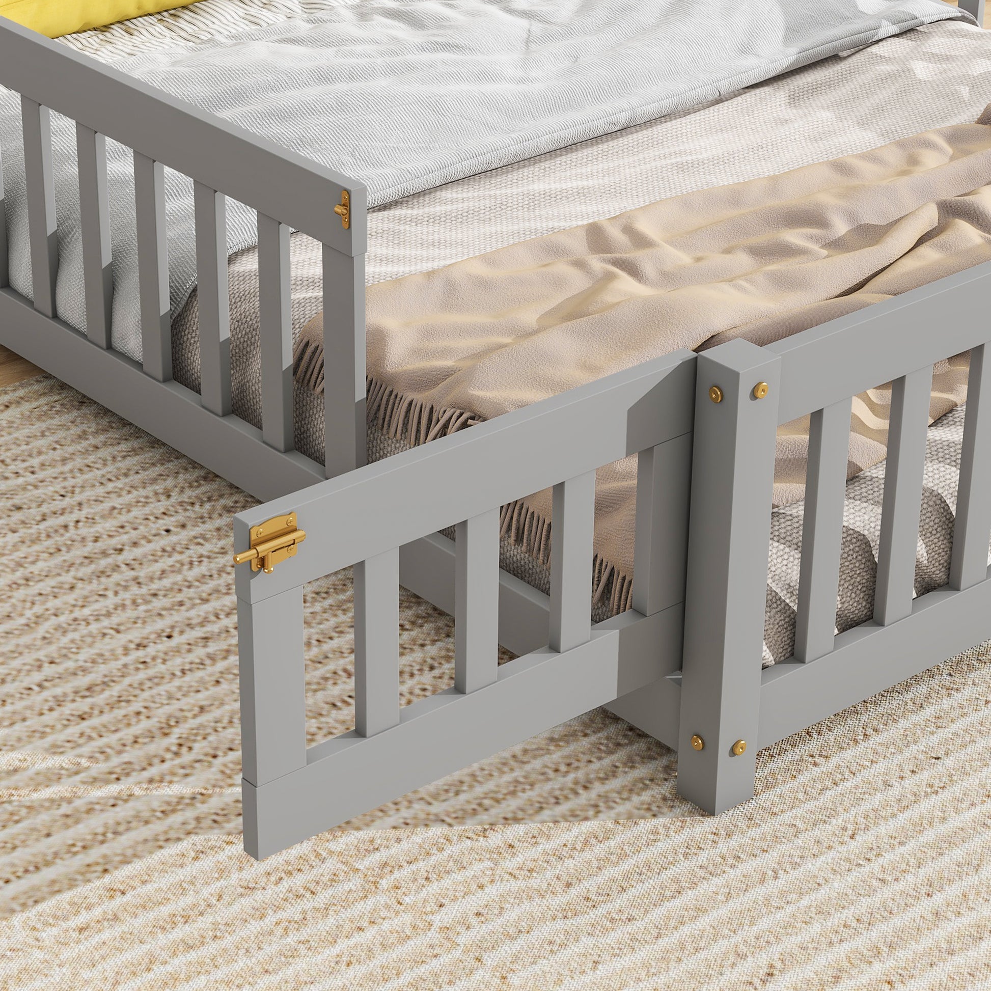 Gray wooden toddler bed with safety rails and gold latch