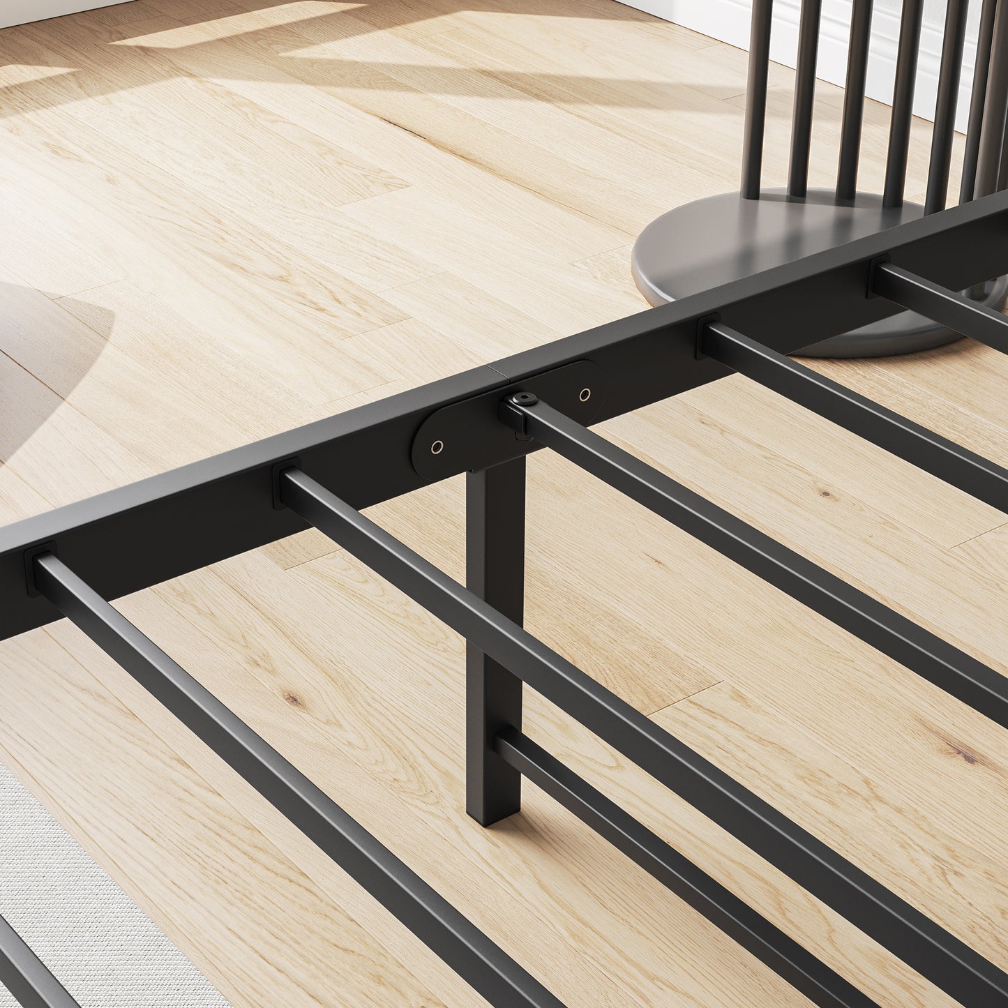 Closeup of a black metal platform bed frame with sturdy slats on a light wood floor