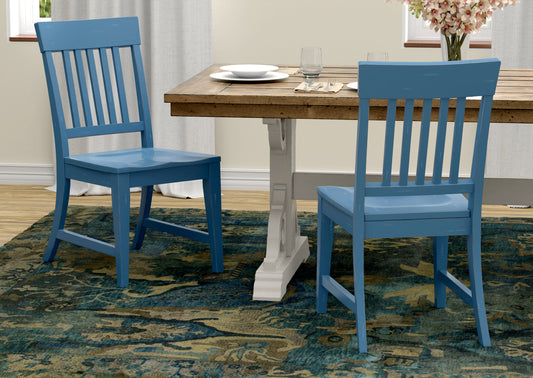 Two blue wooden dining chairs with slatted backs arranged near a rustic wooden table