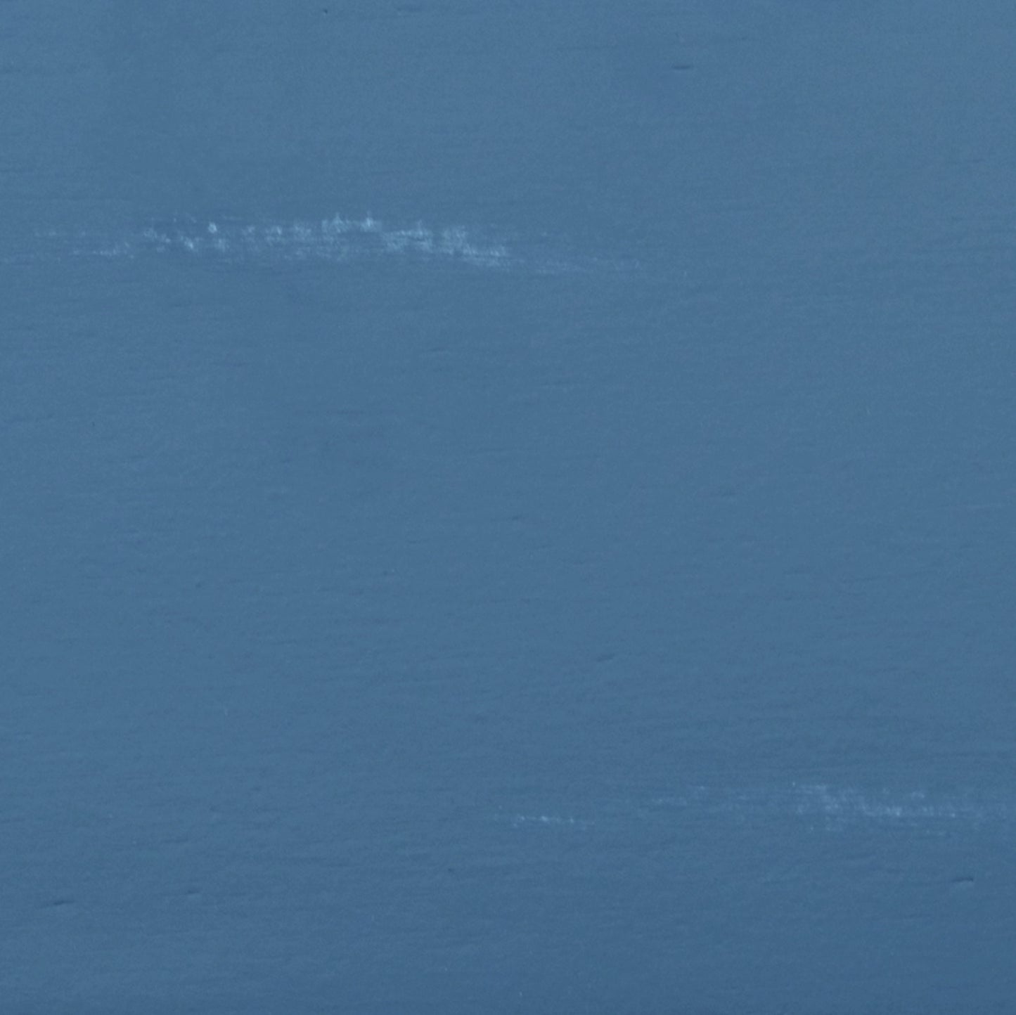 Close up of matte dusty blue paint texture with subtle white brush strokes