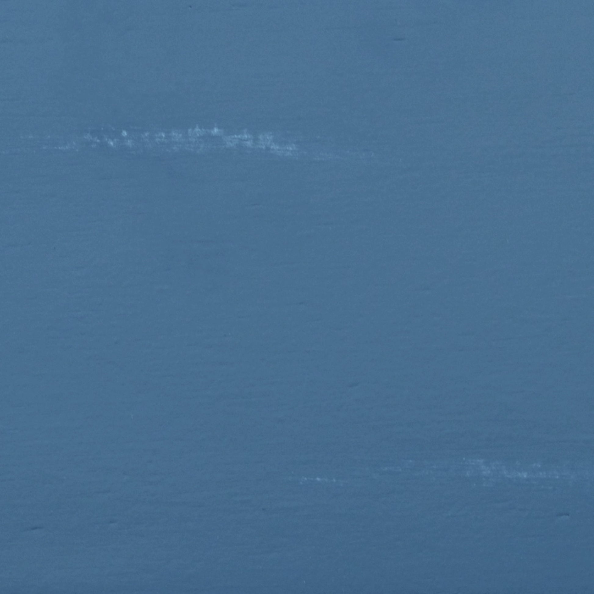 Close up of matte dusty blue paint texture with subtle white brush strokes
