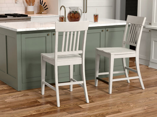 Two white wooden slatback counter chairs at a kitchen island