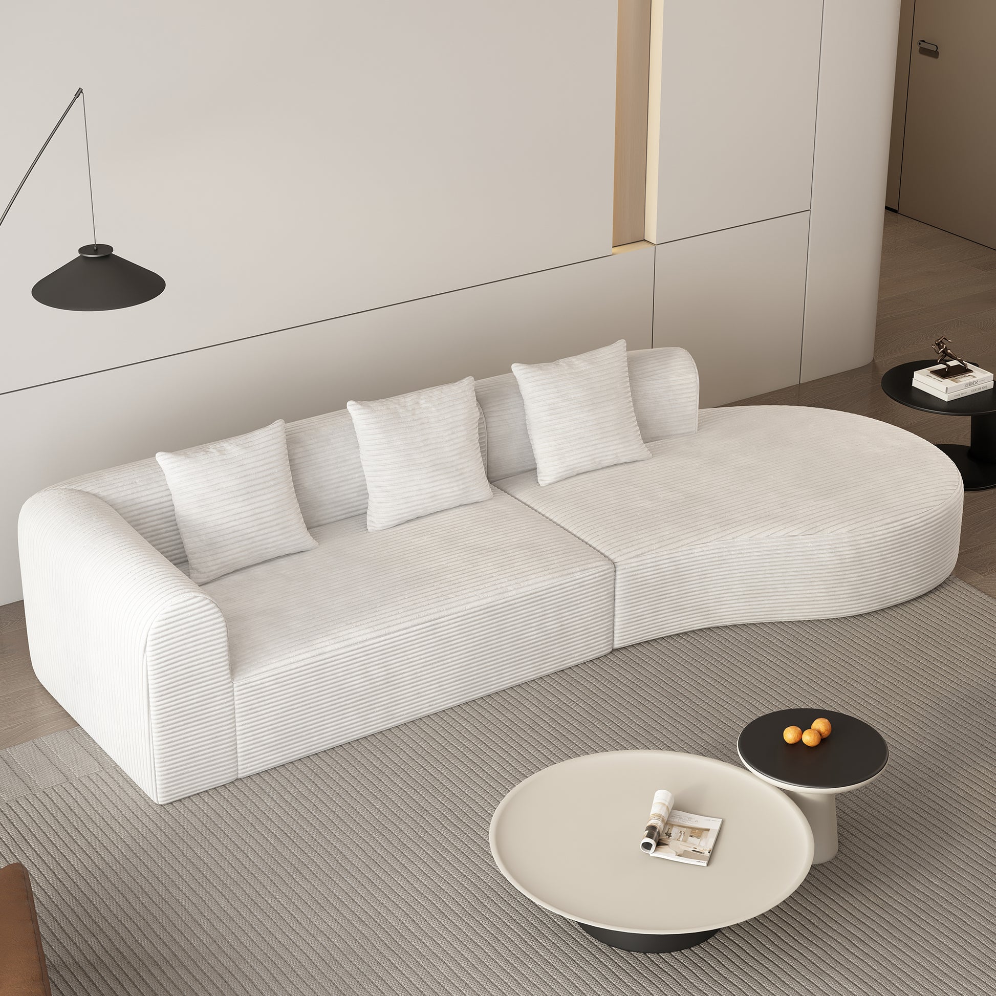 Curved white corduroy sofa with plush pillows in a modern living room