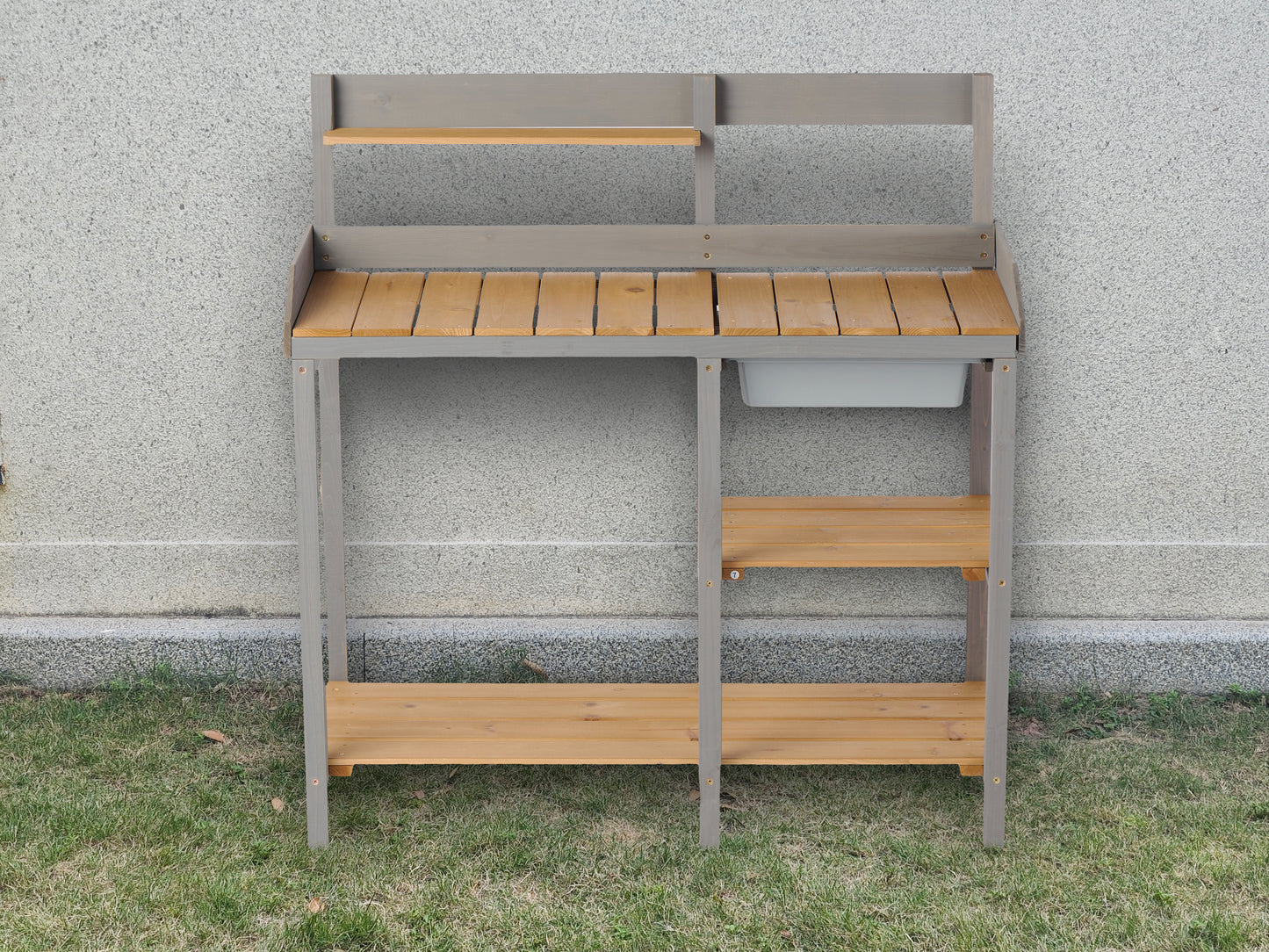 Gray wooden potting bench with two shelves and a sink for gardening projects