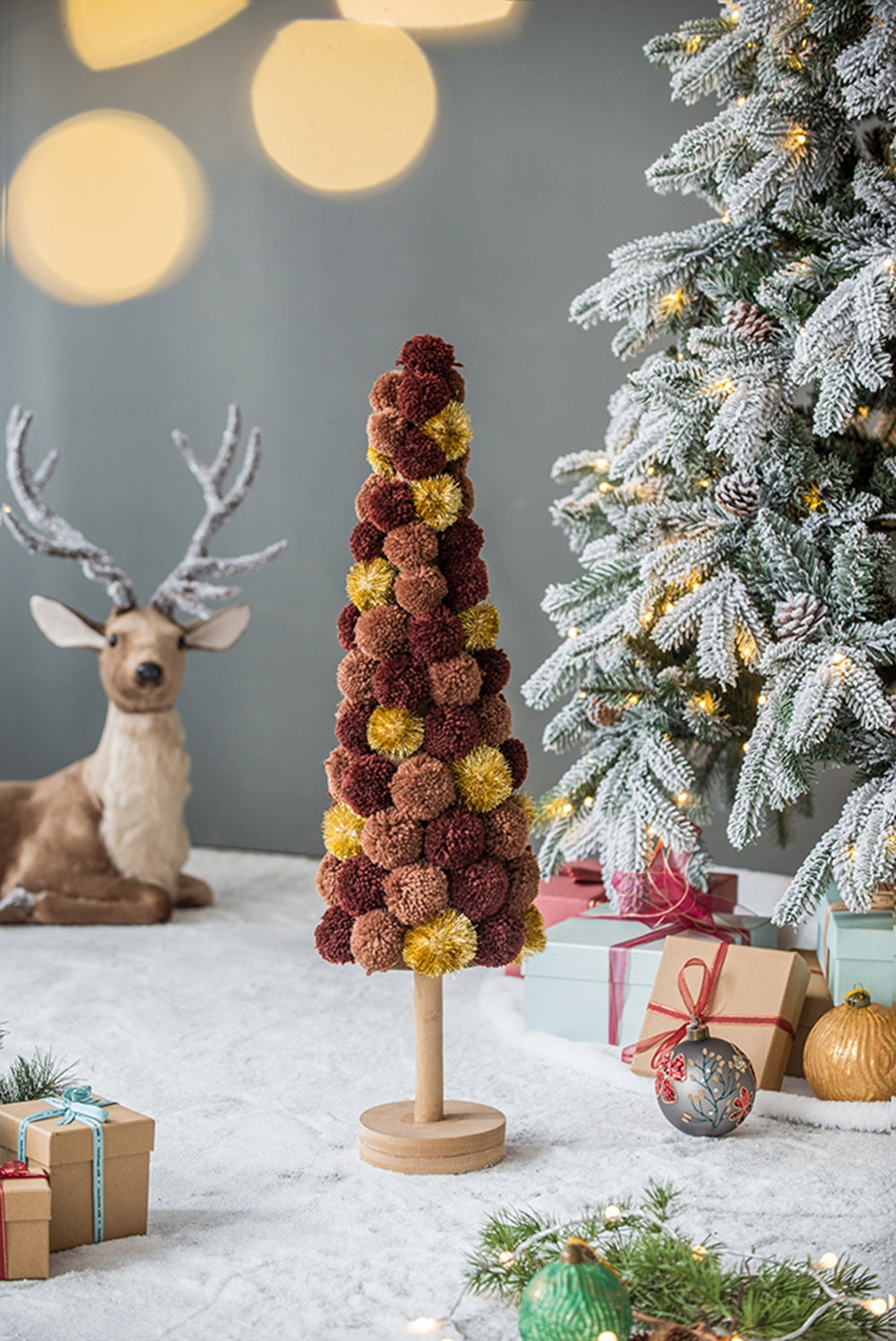 Conical pom pom Christmas tree in brown and gold with wooden stand