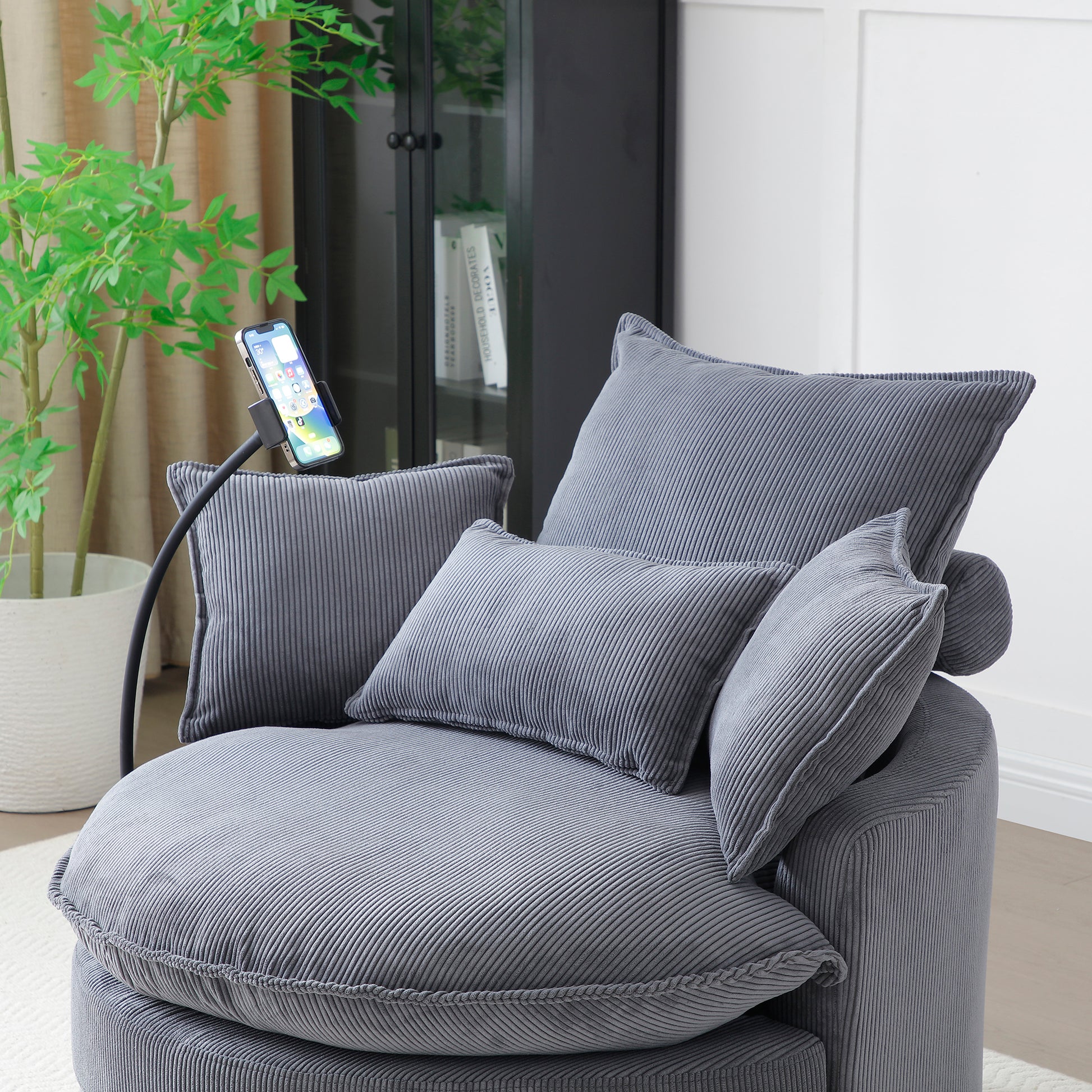 Plush grey corduroy accent chair with plush pillows perfect for a cozy reading nook
