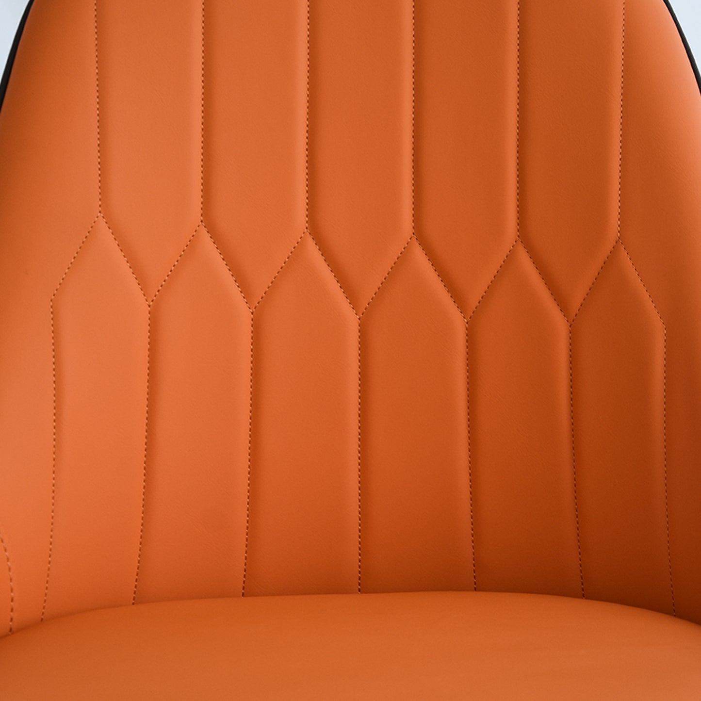 Close up of orange leather chair upholstery with diamond stitching detail