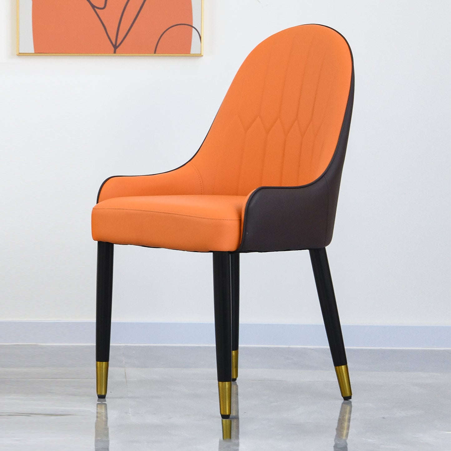 Orange upholstered accent chair with dark brown sides and black legs with gold accents