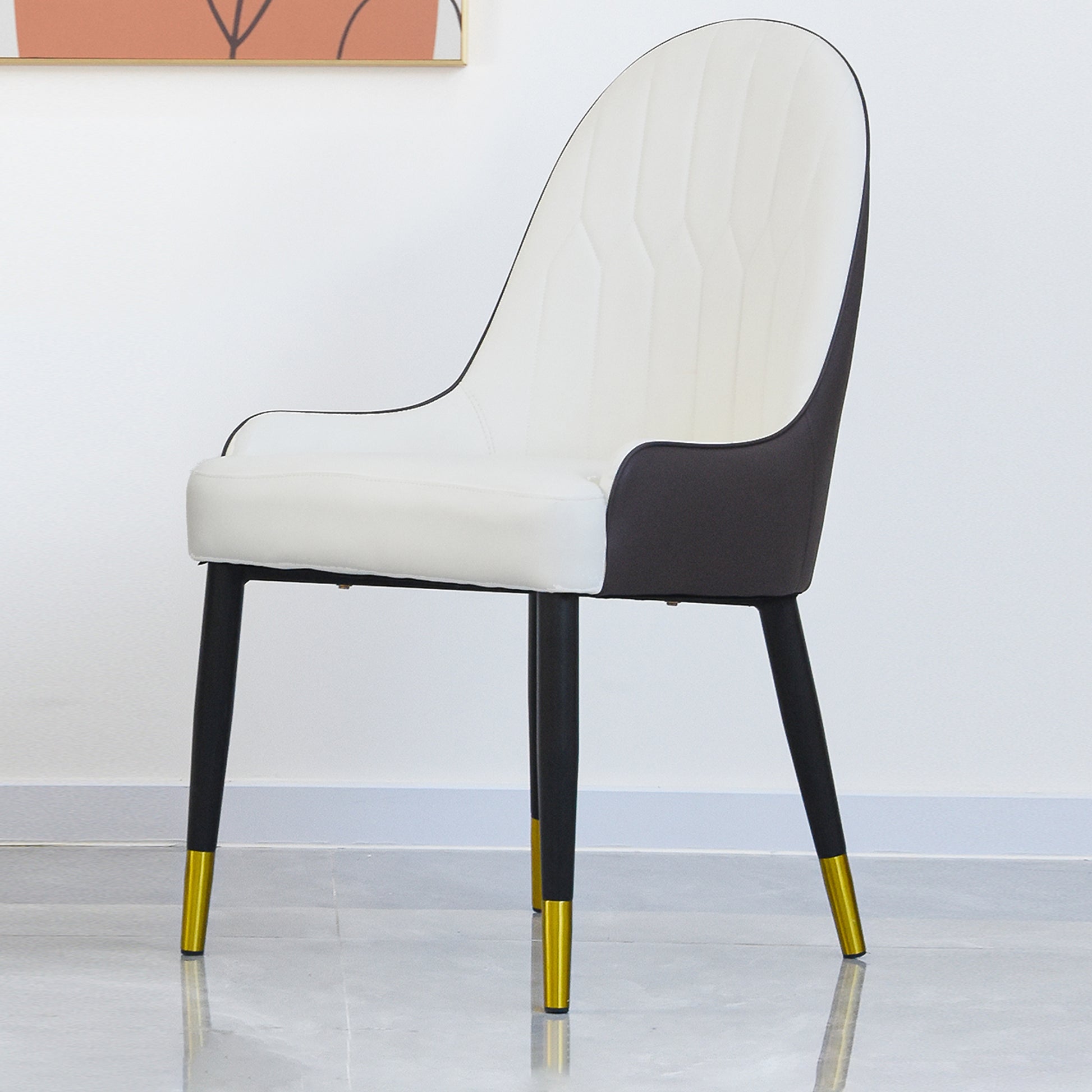 Modern white dining chair with dark grey accents and goldtipped black legs