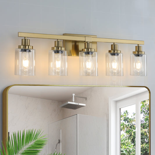 Modern brass bathroom vanity light with five clear glass shades illuminating Edison bulbs
