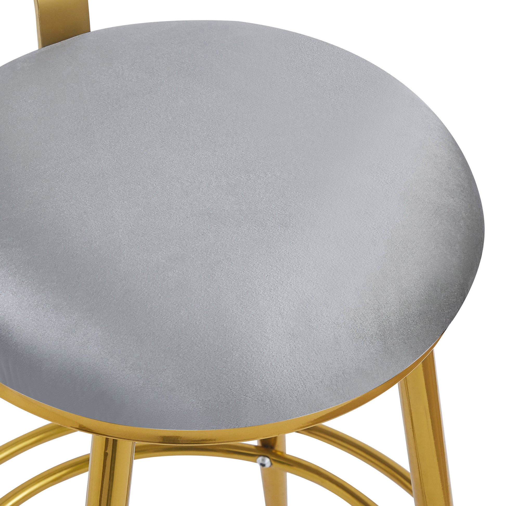 Closeup of a plush gray velvet seat on a gold metal bar stool frame