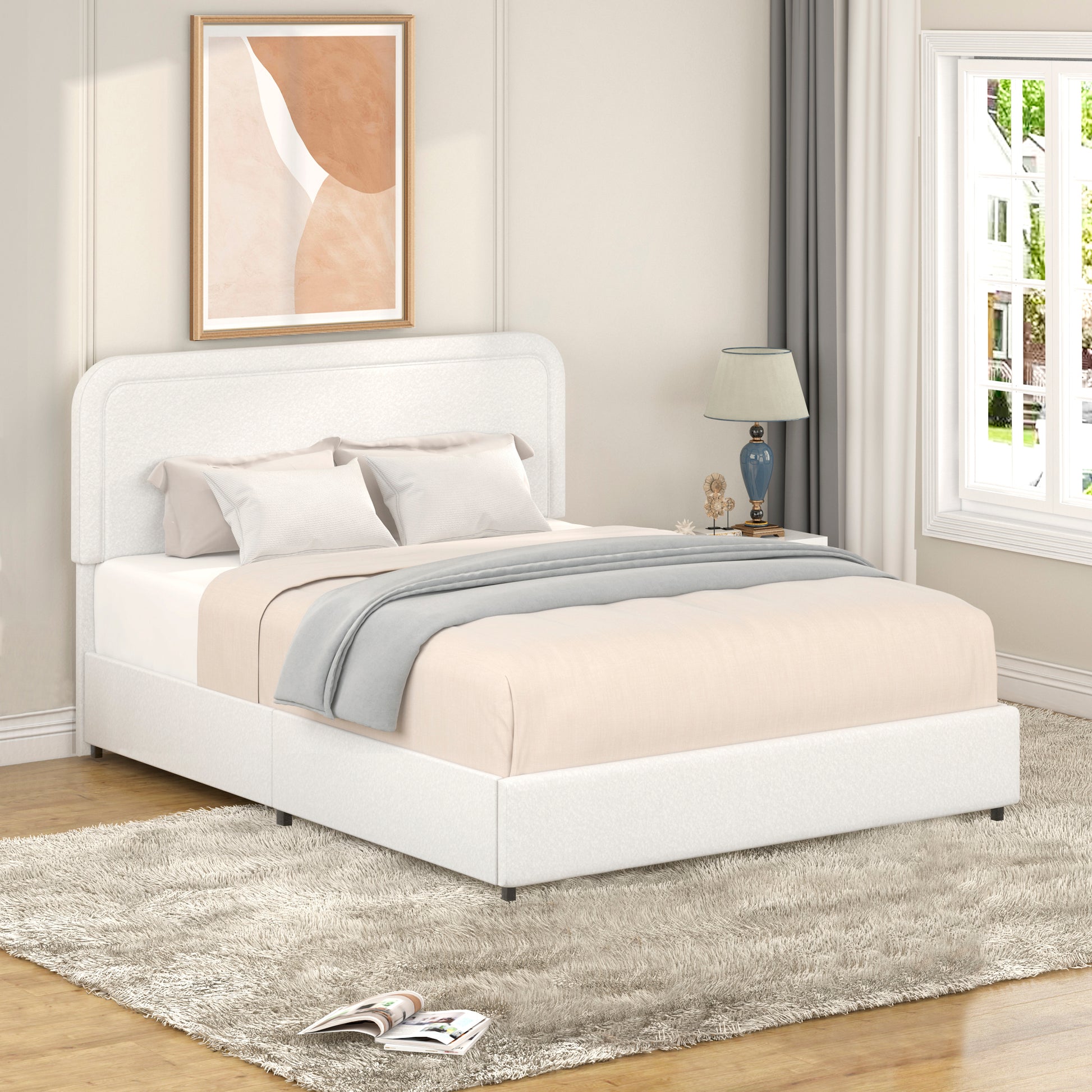 White upholstered platform bed with curved headboard and neutral bedding