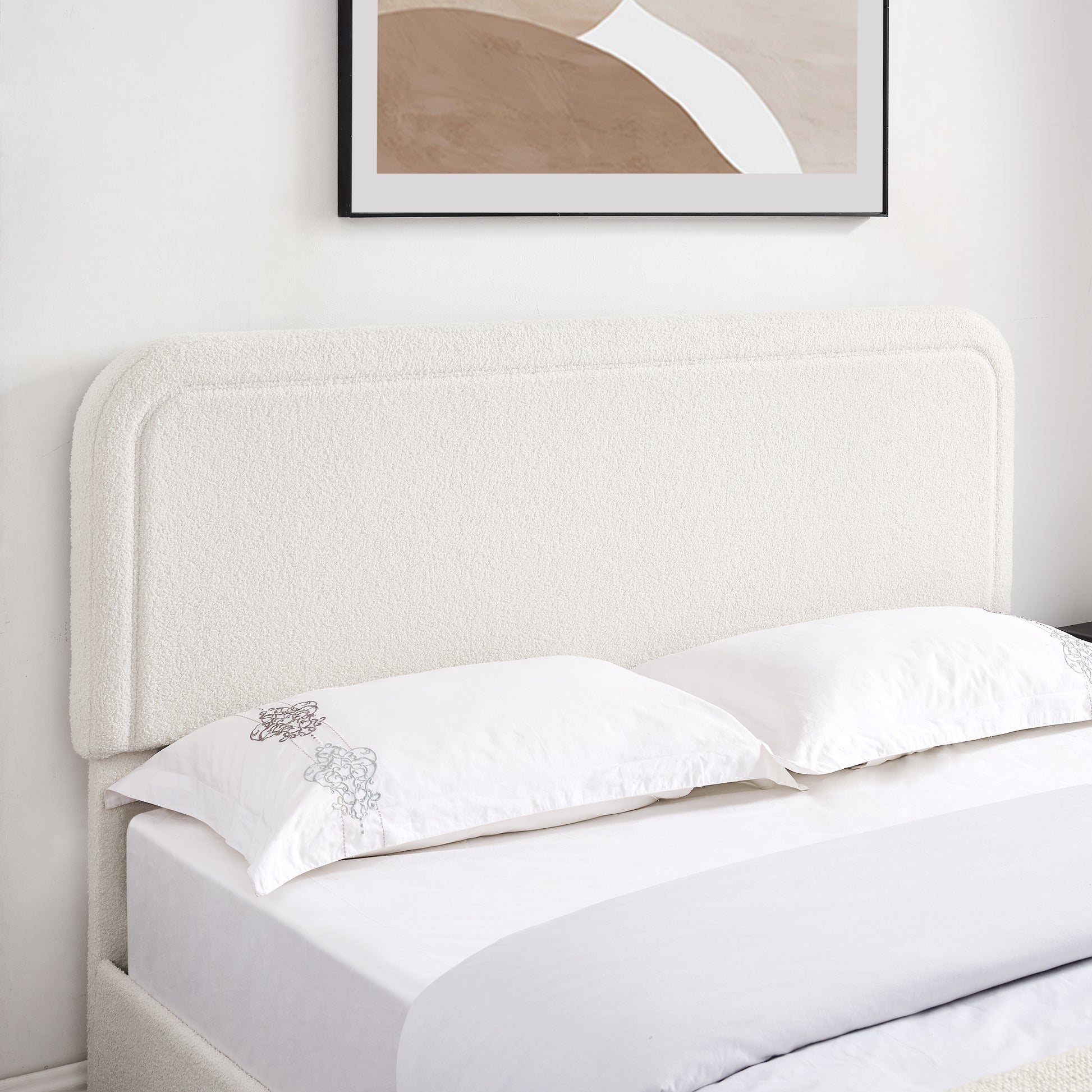 White boucle fabric bed frame with rounded headboard and two pillows