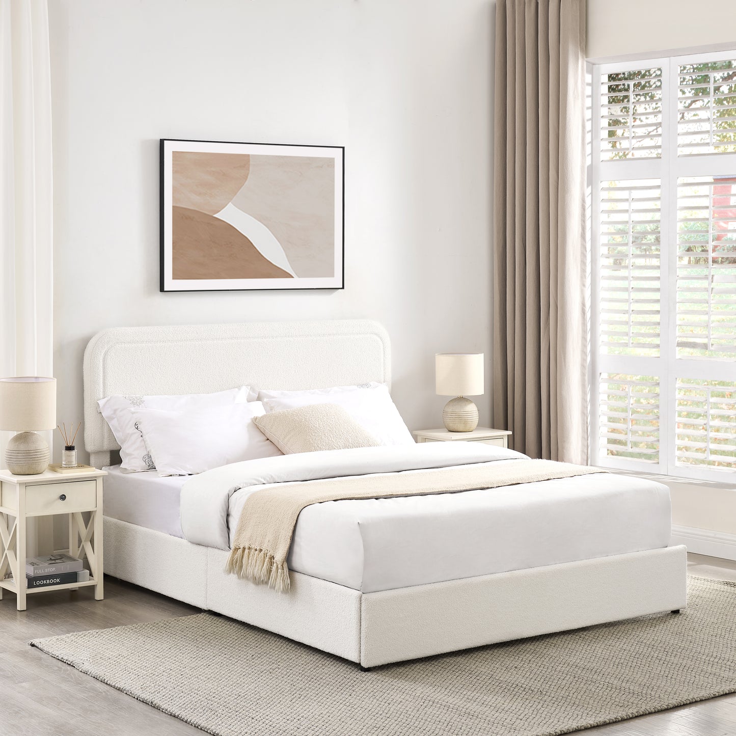 Cream boucl upholstered bed frame with textured pillows and a throw