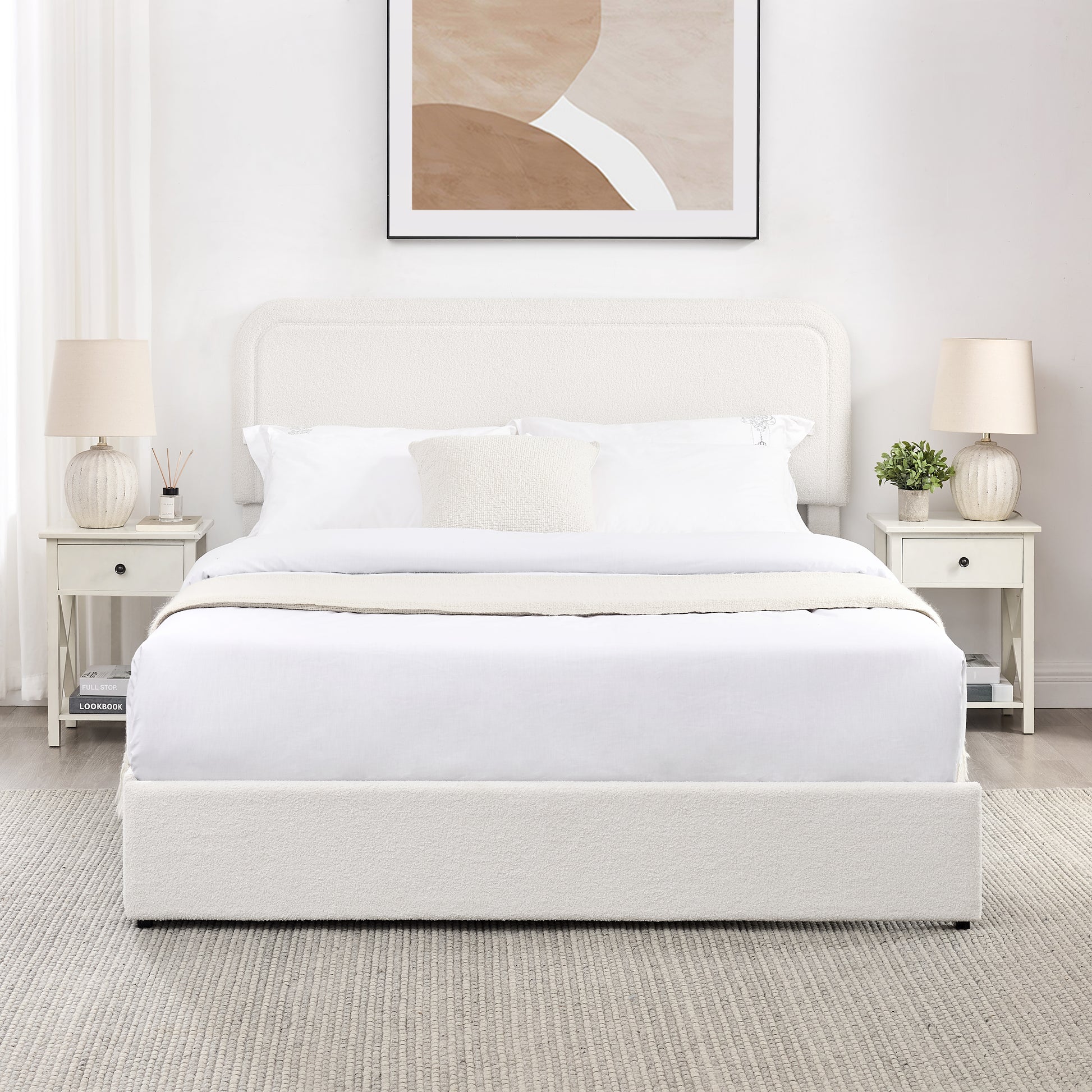 Cream boucle upholstered platform bed with white linens and bedside tables