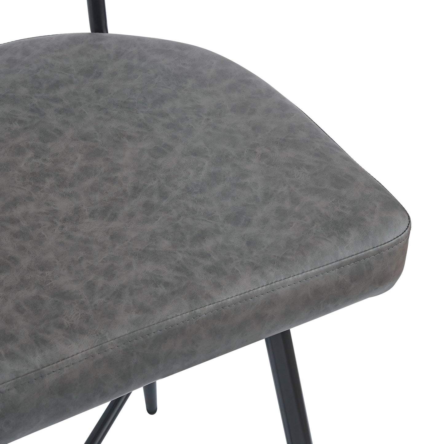Closeup of a textured grey faux leather chair seat with black metal legs perfect for a modern dining room