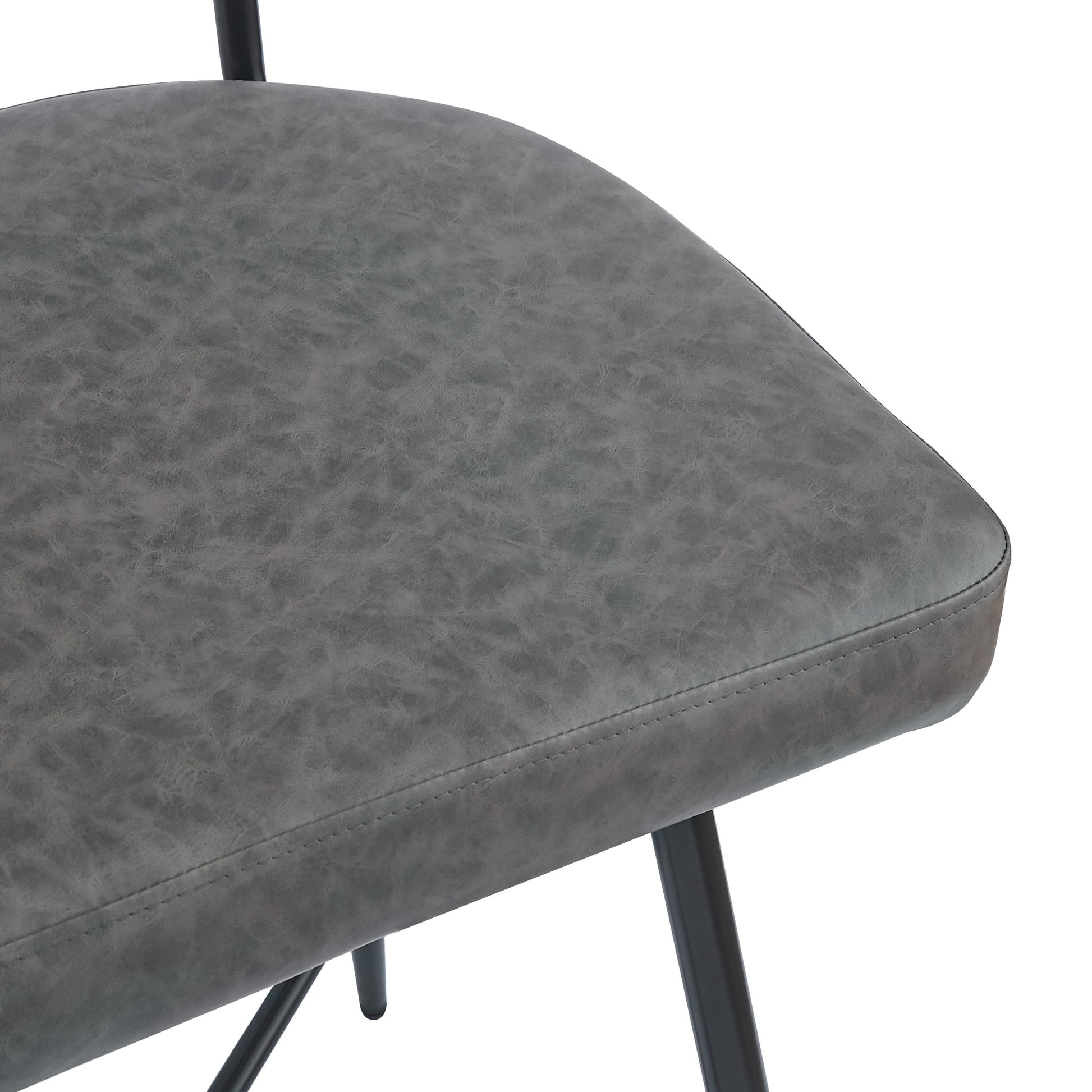 Closeup of a textured grey faux leather chair seat with black metal legs perfect for a modern dining room