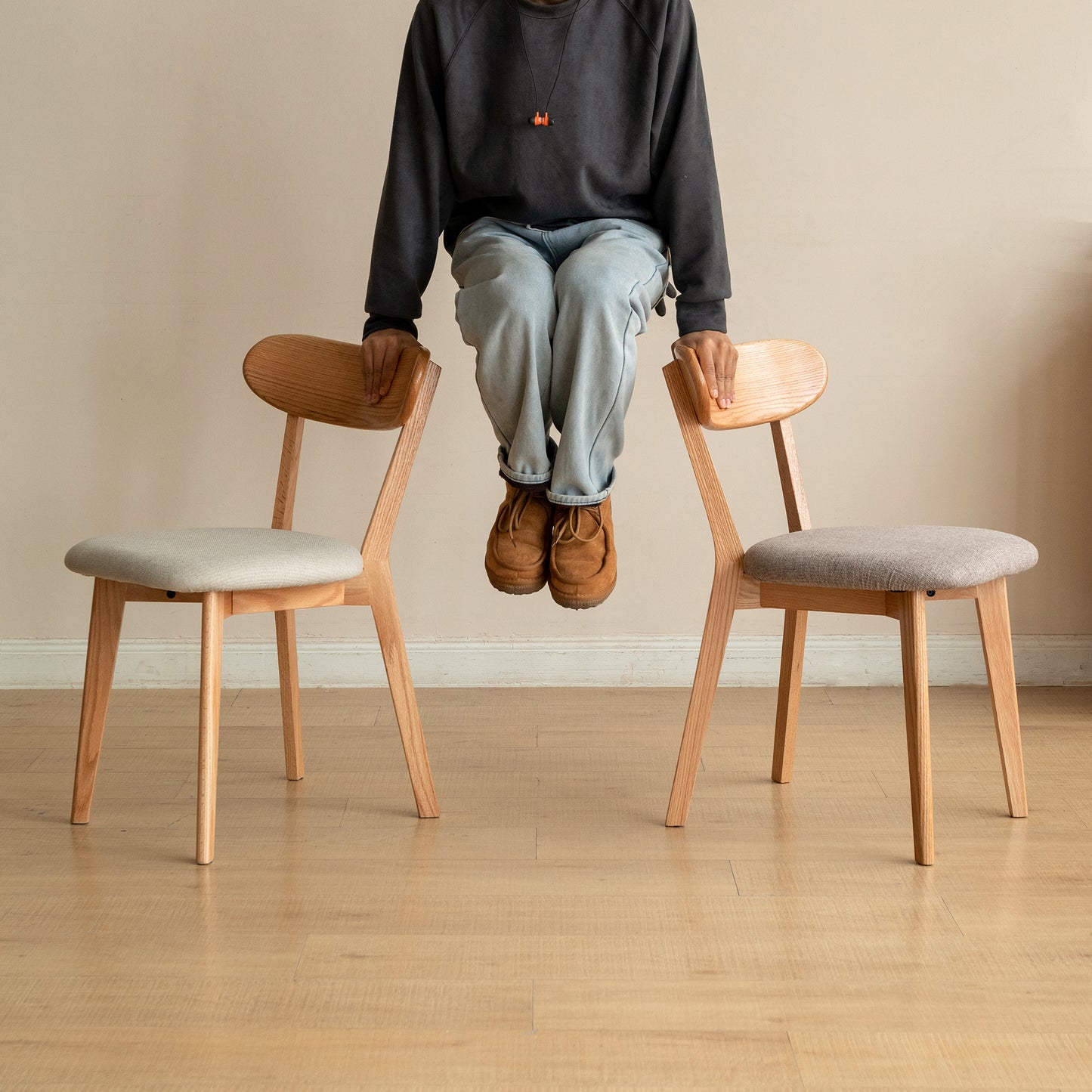 Light wood dining chair with light gray upholstered seat and curved backrest