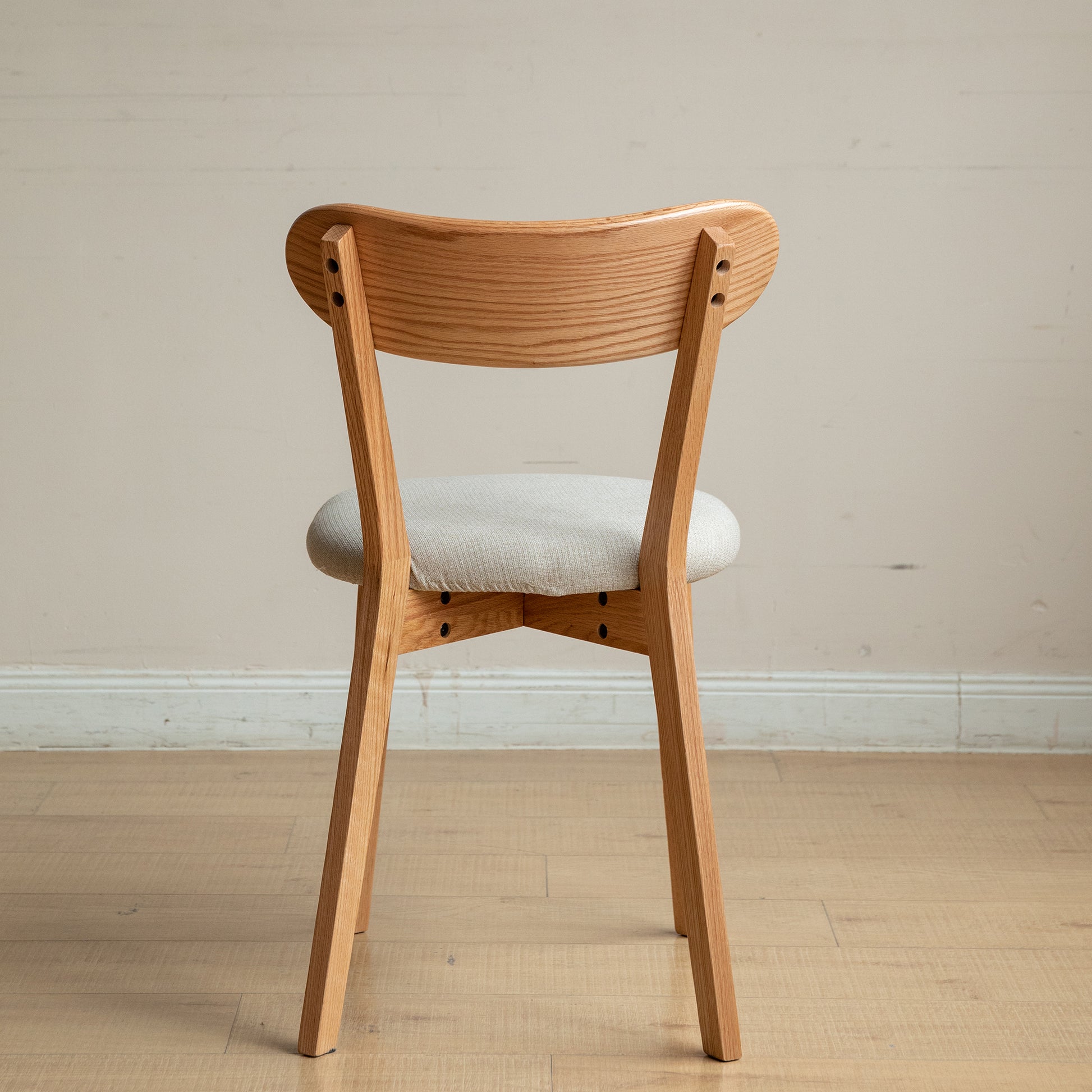 Light oak wooden chair with a curved back and upholstered seat