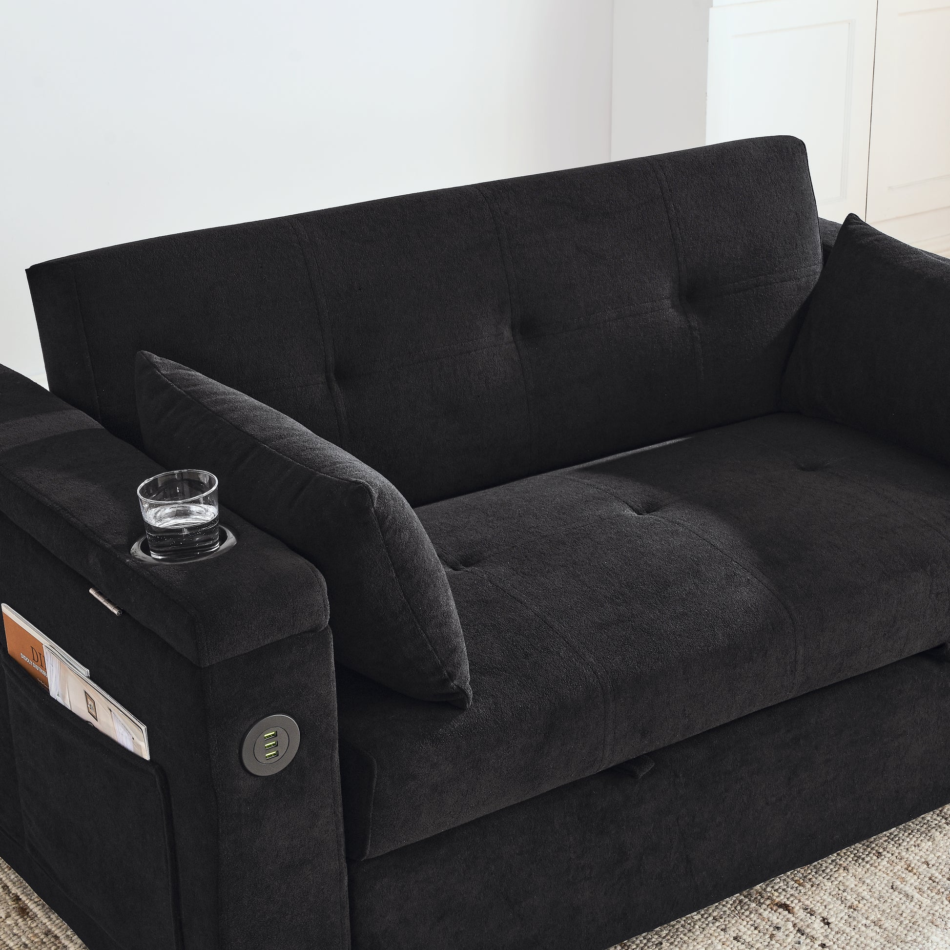 Black fabric loveseat with builtin USB ports and cup holder