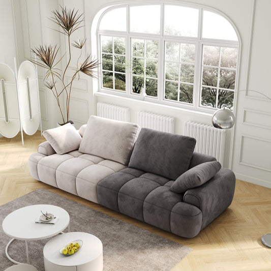 Modular velvet sofa in cream and charcoal featuring deep tufting and plush cushions for ultimate comfort