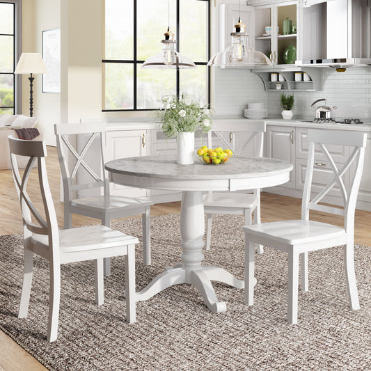 White pedestal base dining table with marble top and four crossback chairs