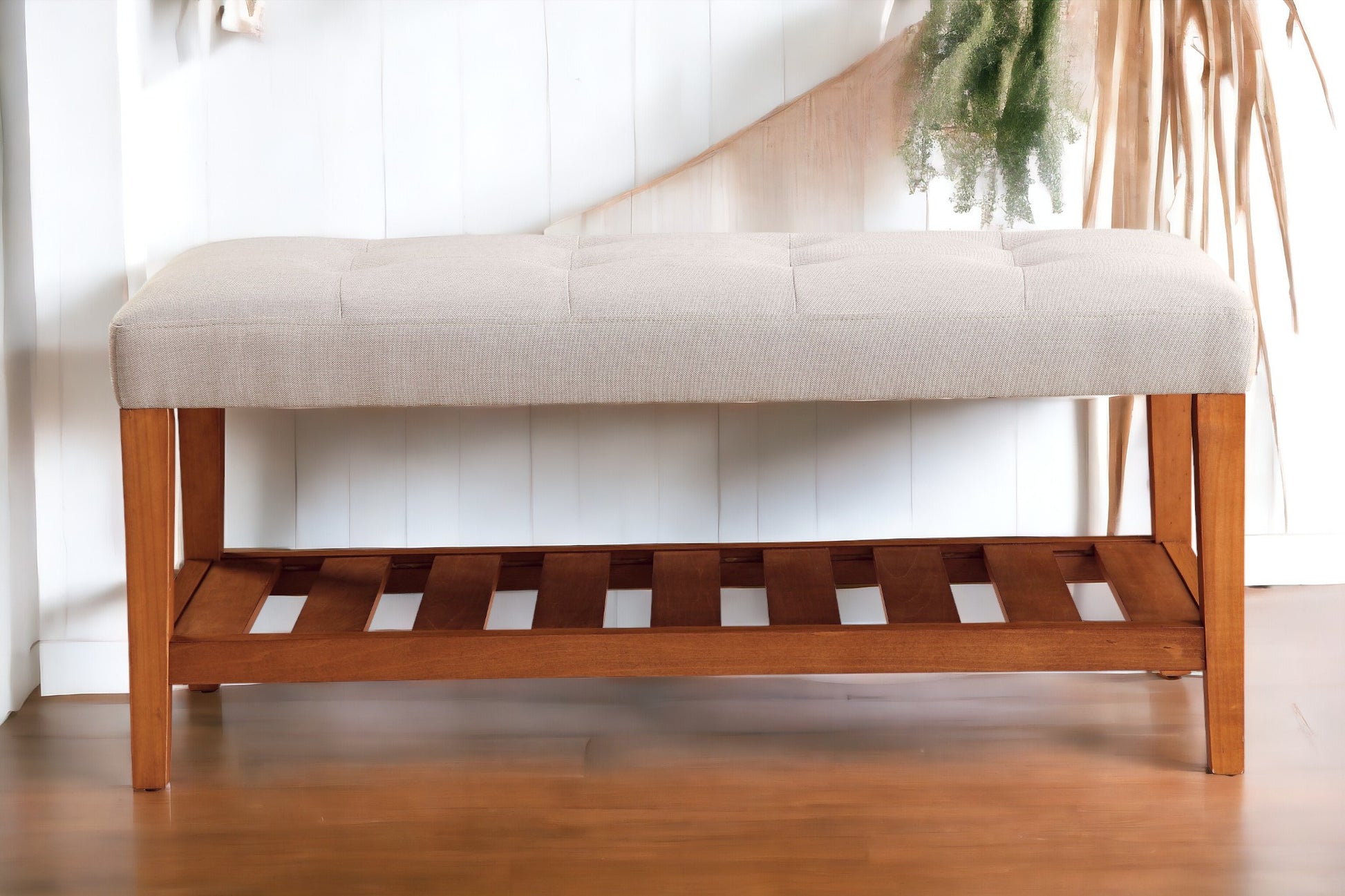 Tufted beige fabric bench with a slatted wooden base