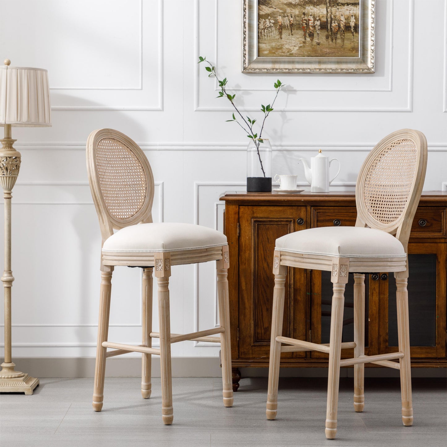 Two light wood cane back bar stools with cream upholstered seats