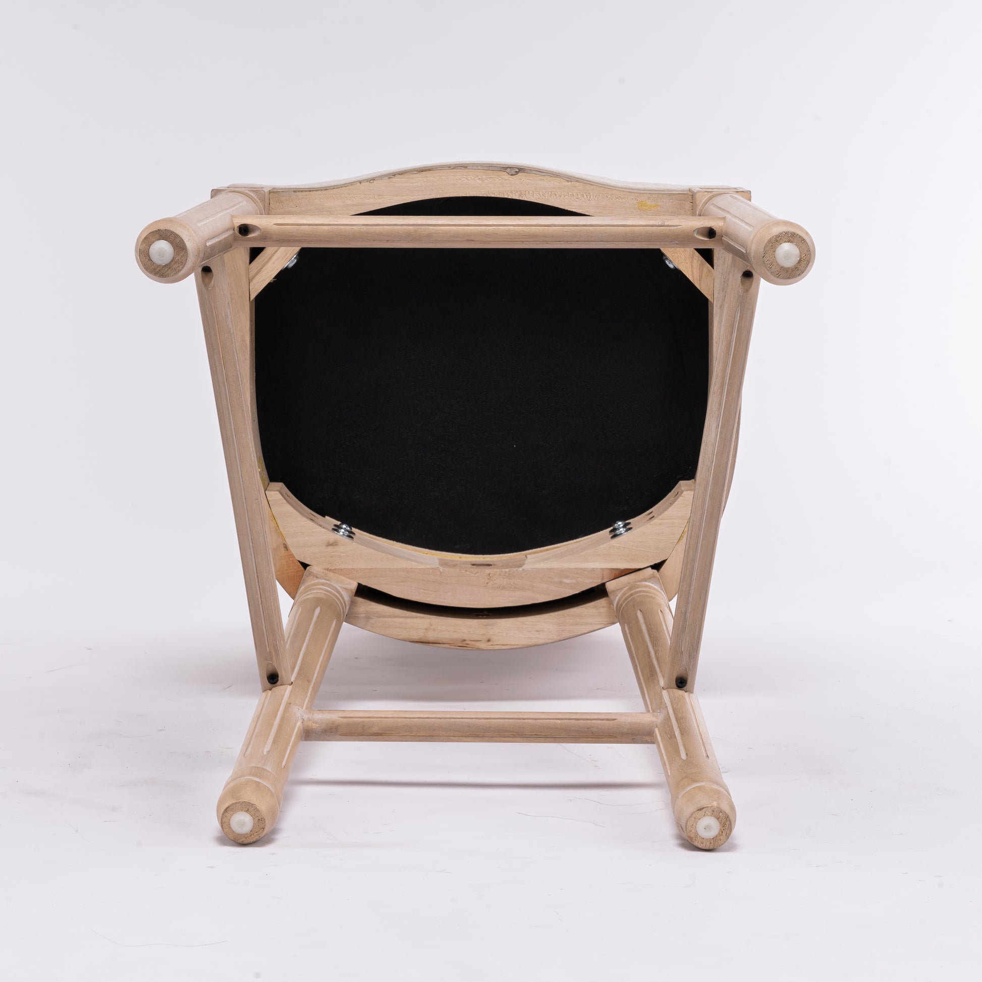 Wooden dining chair with black upholstered seat visible from below