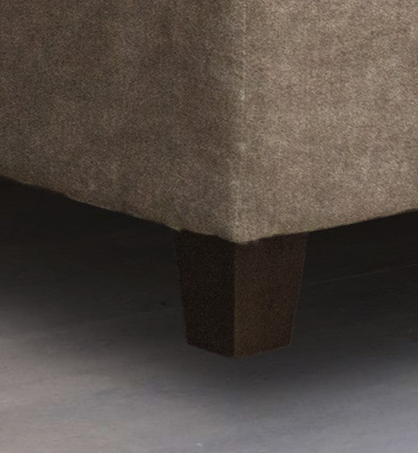 Closeup of a taupe textured fabric couch with dark wood block feet