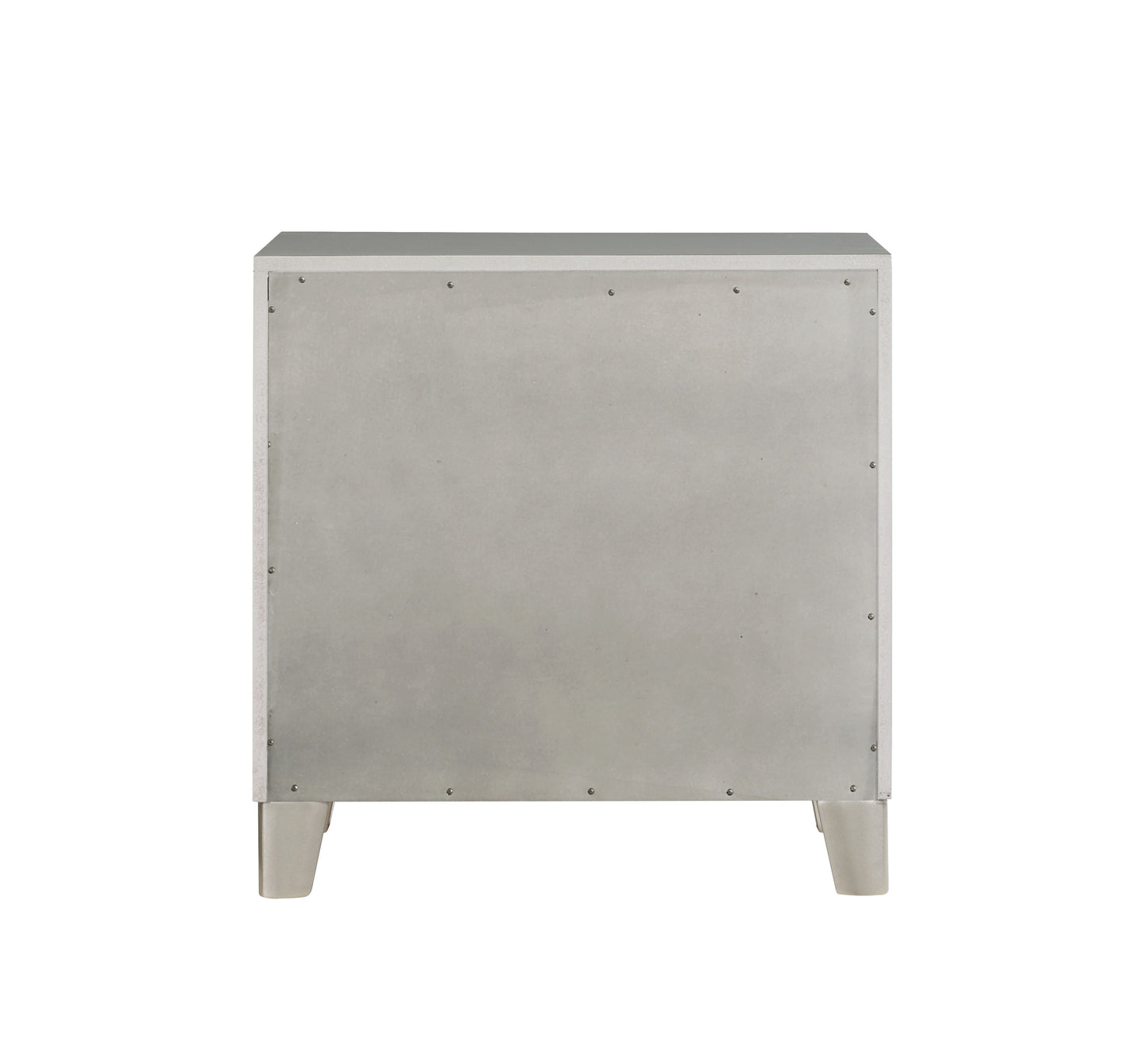 Back view of a white particleboard dresser with four silver legs and visible screws
