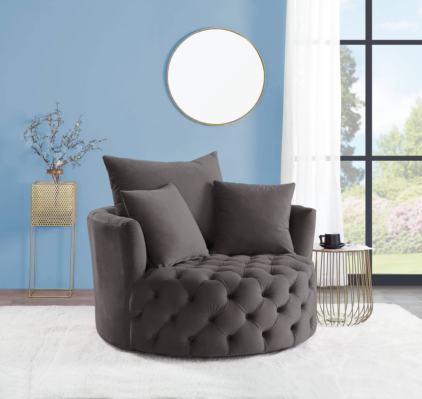 Dark gray velvet swivel chair with tufted base and plush accent pillows