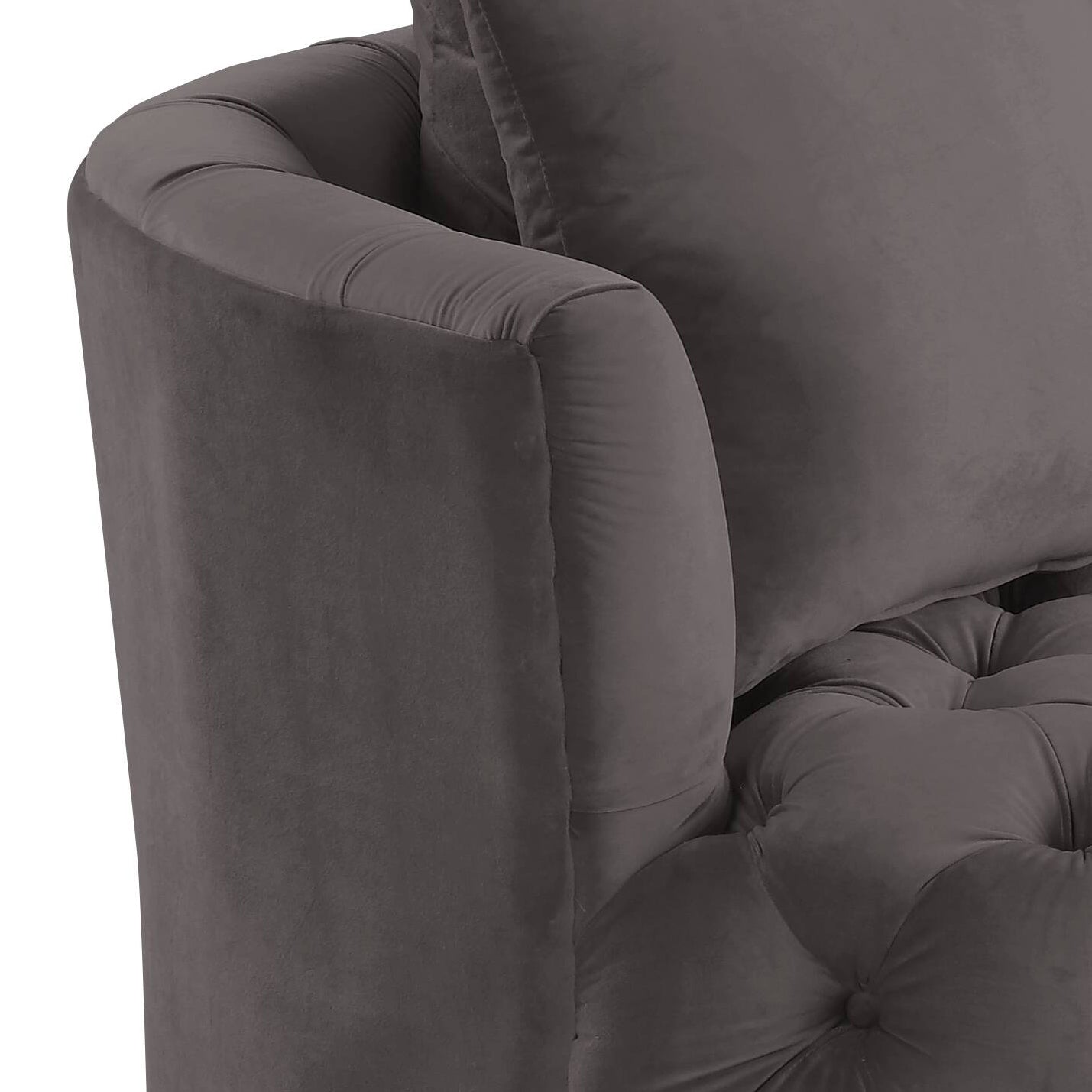 Closeup of a plush grey velvet tufted armchair with elegant rolled arms