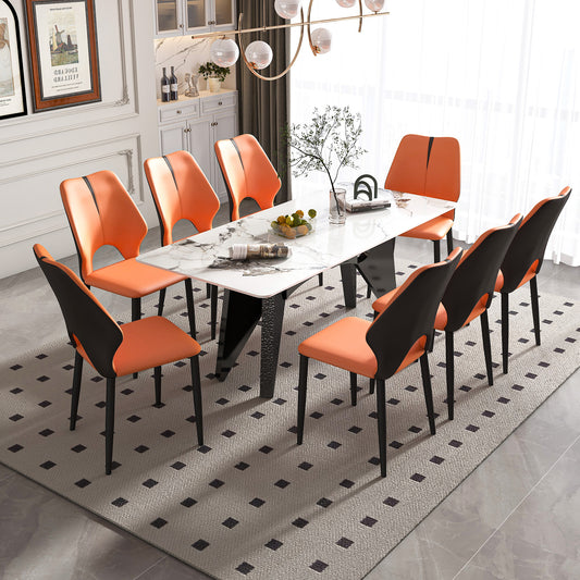 Orange upholstered dining chairs with black accents around a marbletop dining table
