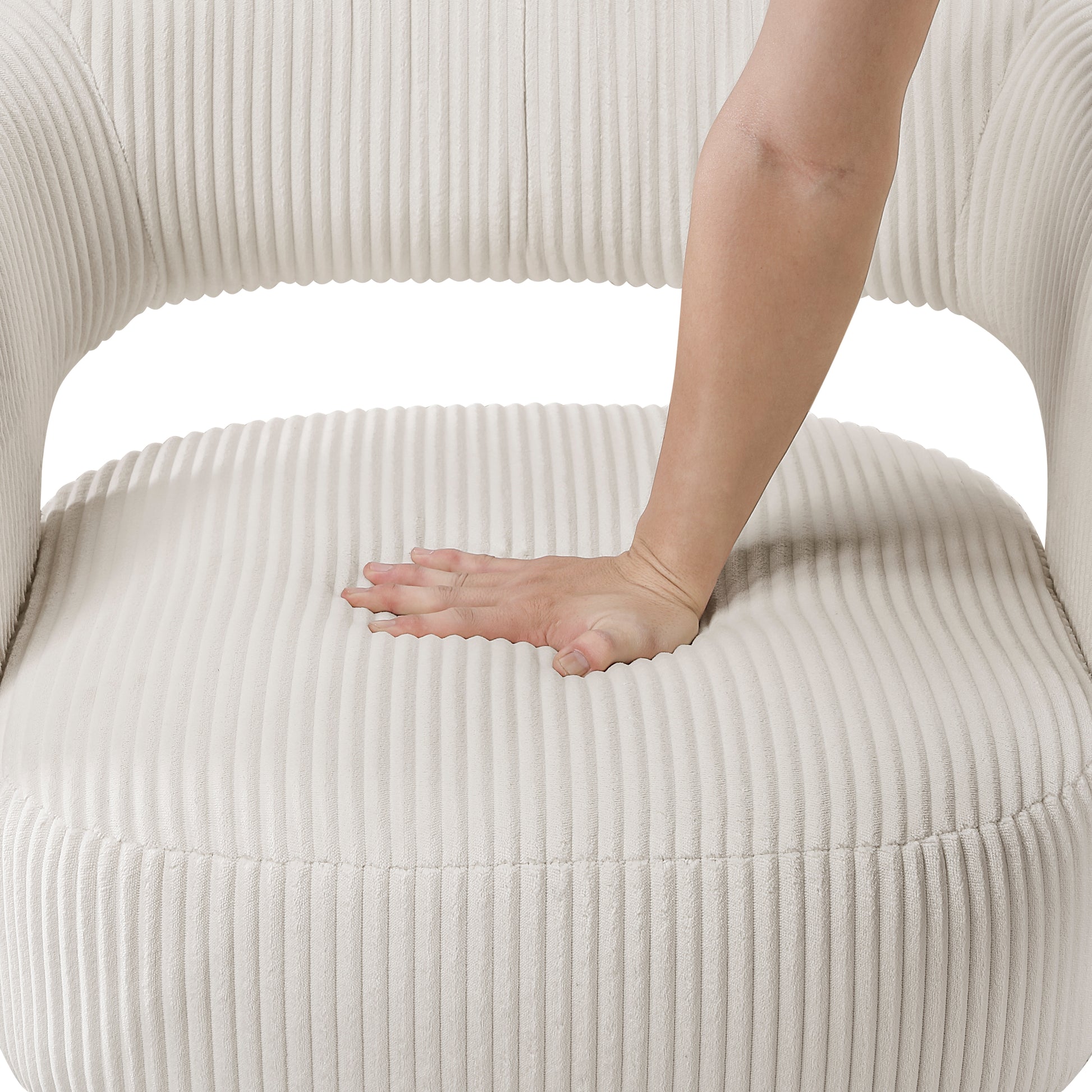 Hand pressing soft ivory corduroy chair seat to show comfort
